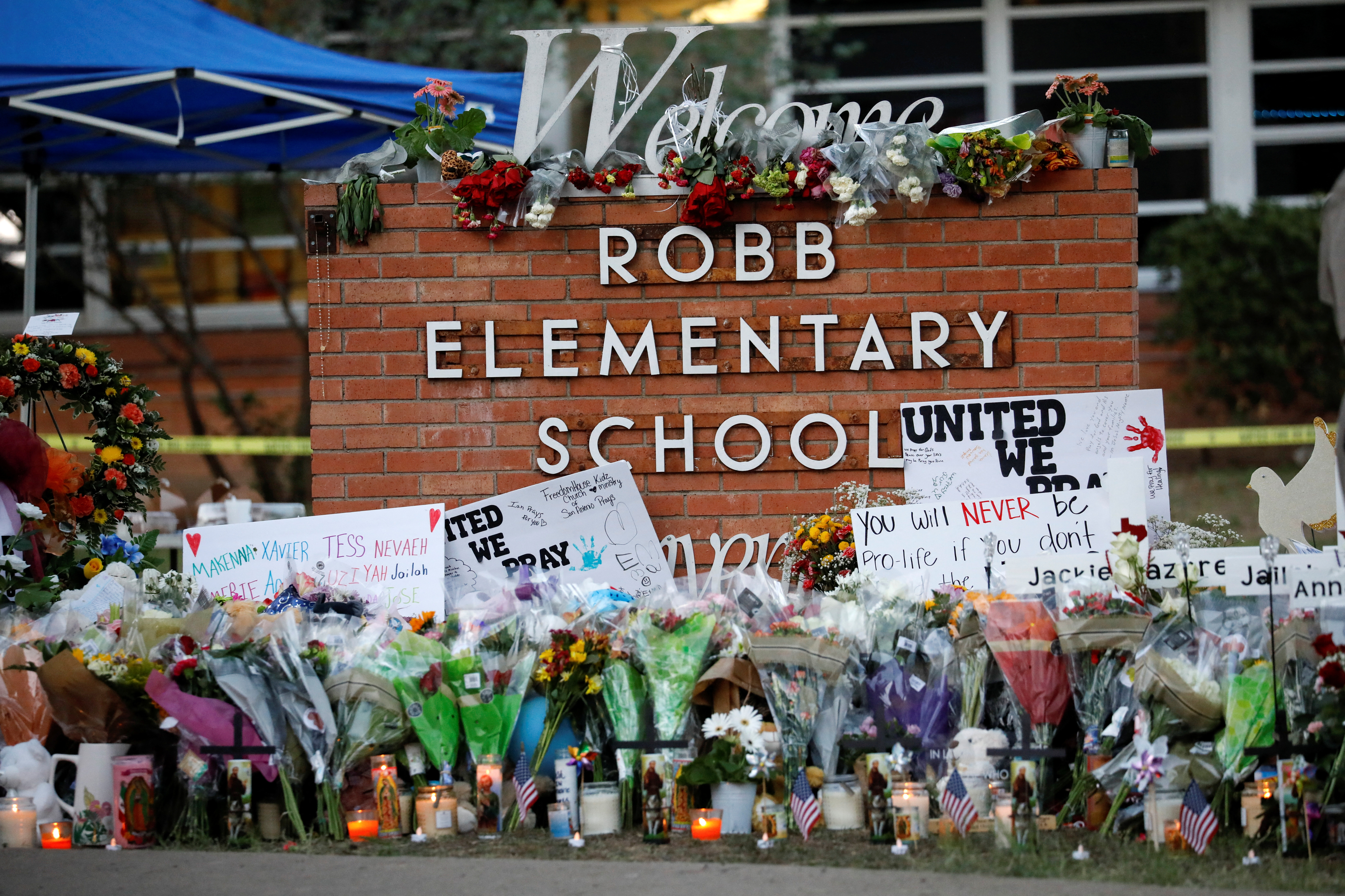 Flores, velas y carteles en un monumento a las víctimas del tiroteo en la escuela Robb Elementary, tres días después de que un pistolero matara a diecinueve niños y dos profesores, en Uvalde, Texas, Estados Unidos 27 de mayo de 2022. REUTERS/Marco Bello