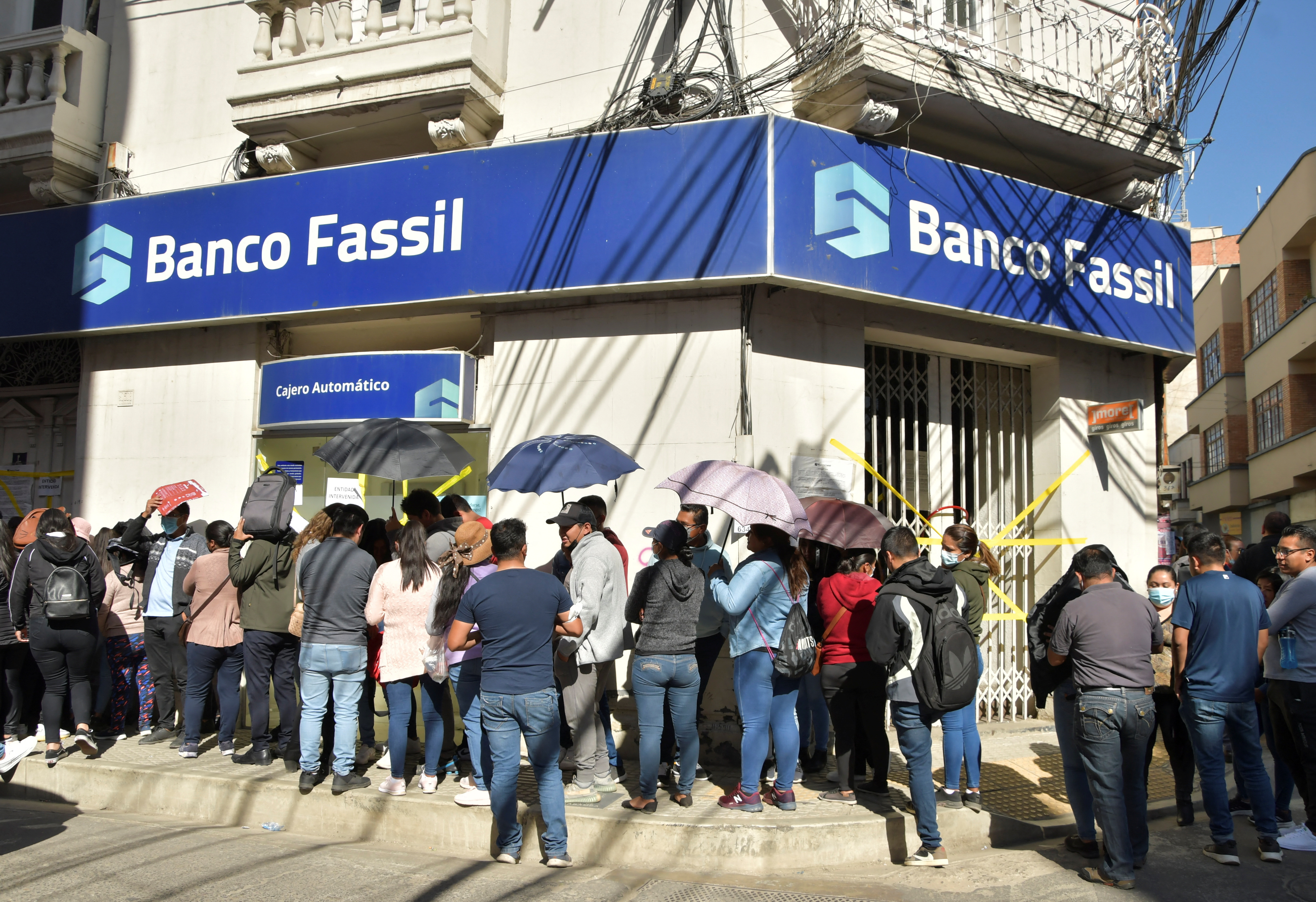 Empleados del Banco Fassil afuera de una sede tras la intervención del gobierno (Reuters)