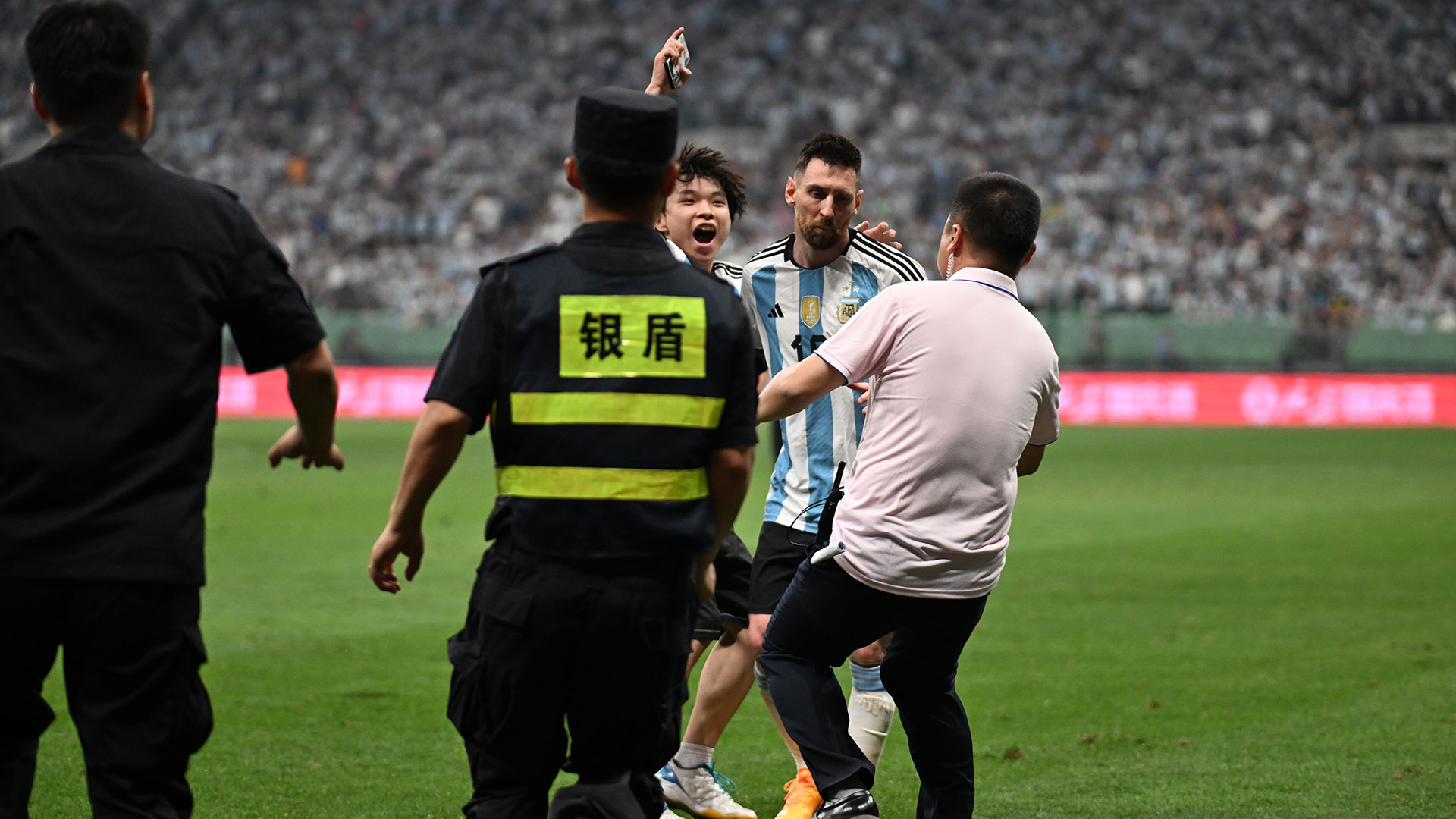 Un hincha invadió el campo de juego para abrazar a Lionel Messi en el amistoso entre Argentina y Australia en Beijing (Di Yin/Getty Images)