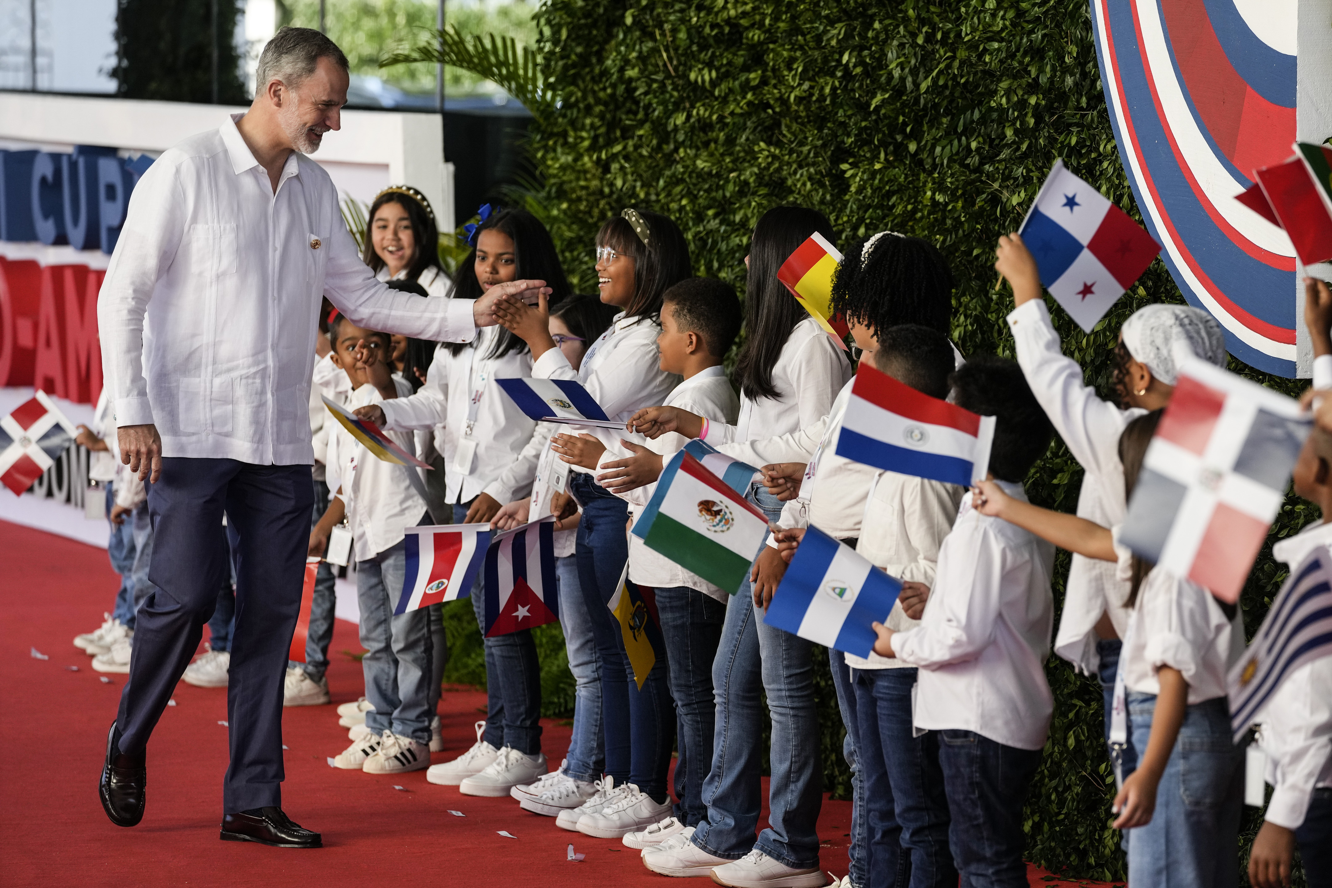 El rey Felipe VI de España saluda a los niños a su llegada a la sesión de la 28ª Cumbre Iberoamericana, en Santo Domingo, República Dominicana, el sábado 25 de marzo de 2022. (Foto AP/Ariana Cubillos)