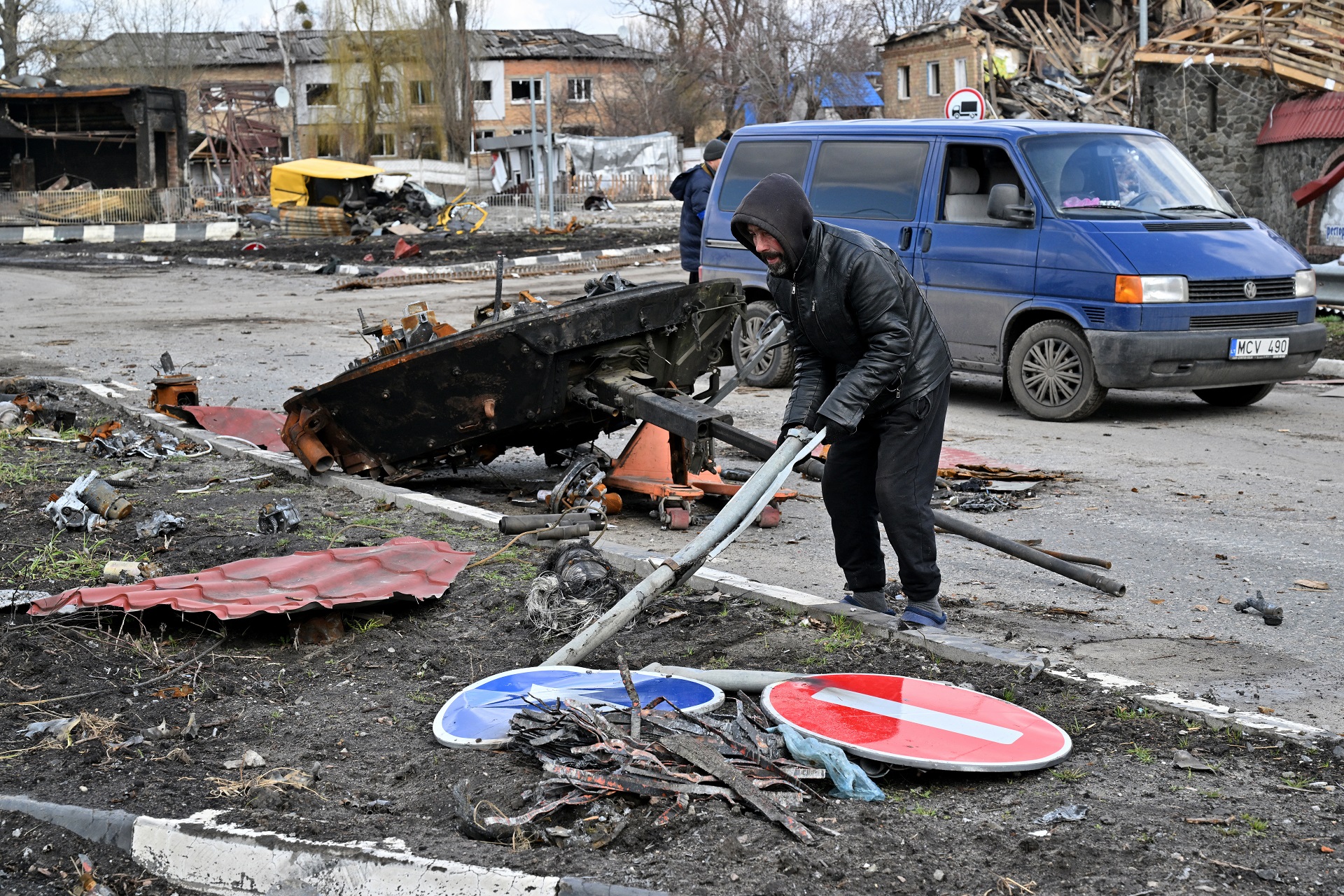 Un hombr remueve la basura entre los restos de un blindado ruso destruido (AFP)