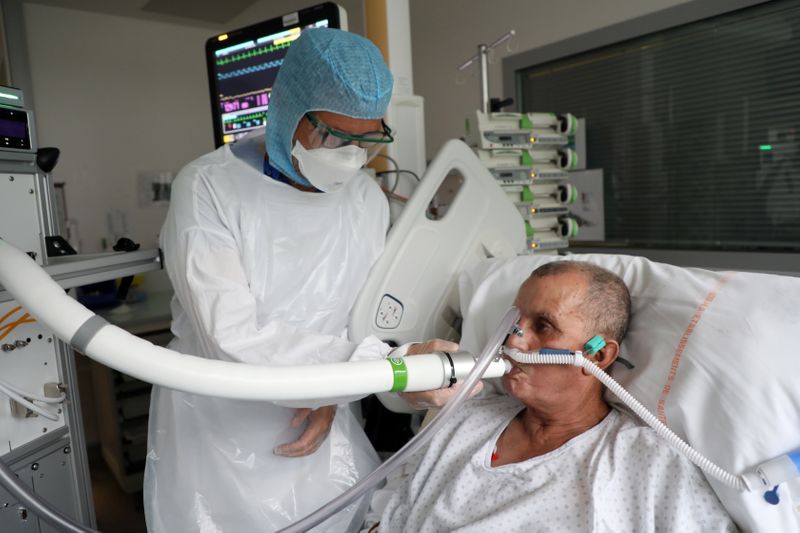 Christian George, director de investigación del Centro Nacional de Investigación Científica, ayuda a un paciente que sufre de COVID-19 en el Hospital La Croix-Rousse en Lyon, Francia. 22 de julio, 2020 (REUTERS/Yiming Woo)