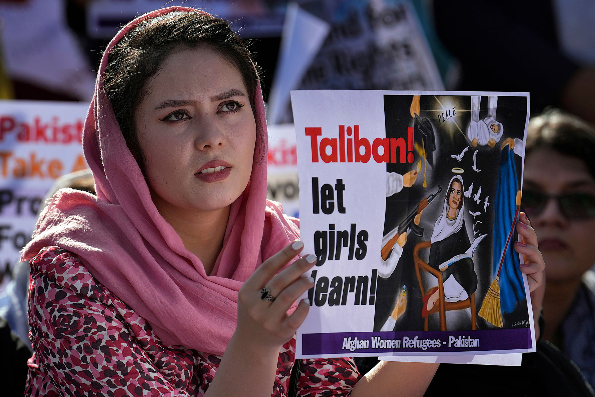 Una refugiada afgana participa en una manifestación en Islamabad, Pakistán, con un cartel pidiendo a los talibanes que dejen estudiar a las mujeres.