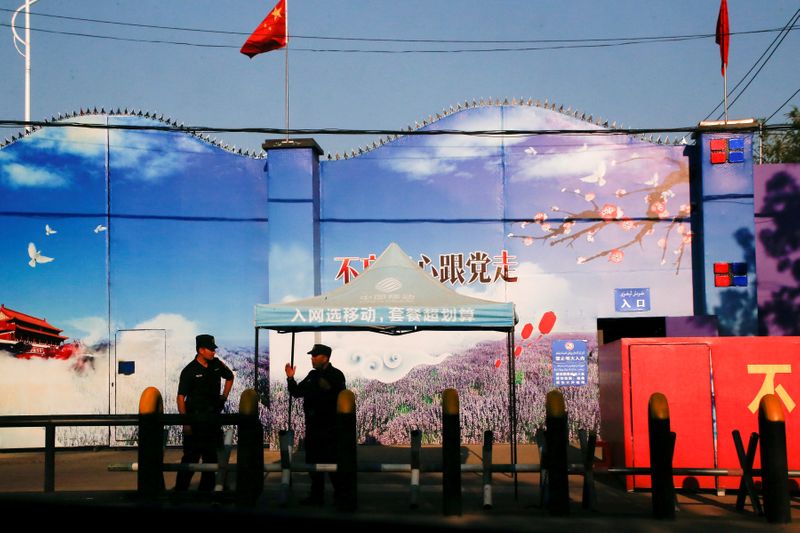 Guardias de seguridad en los portones del centro de trabajos forzados levantado por el régimen chino en la Región Autónoma Uigur de Xinjiang