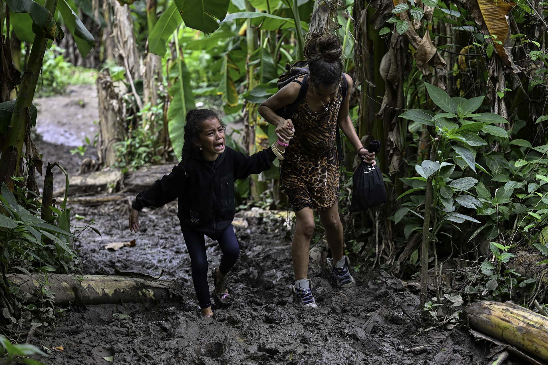 Una madre junto con su hija que huyeron de Venezuela atraviesan el paso de la Provincia de Darien, en Panamá.
