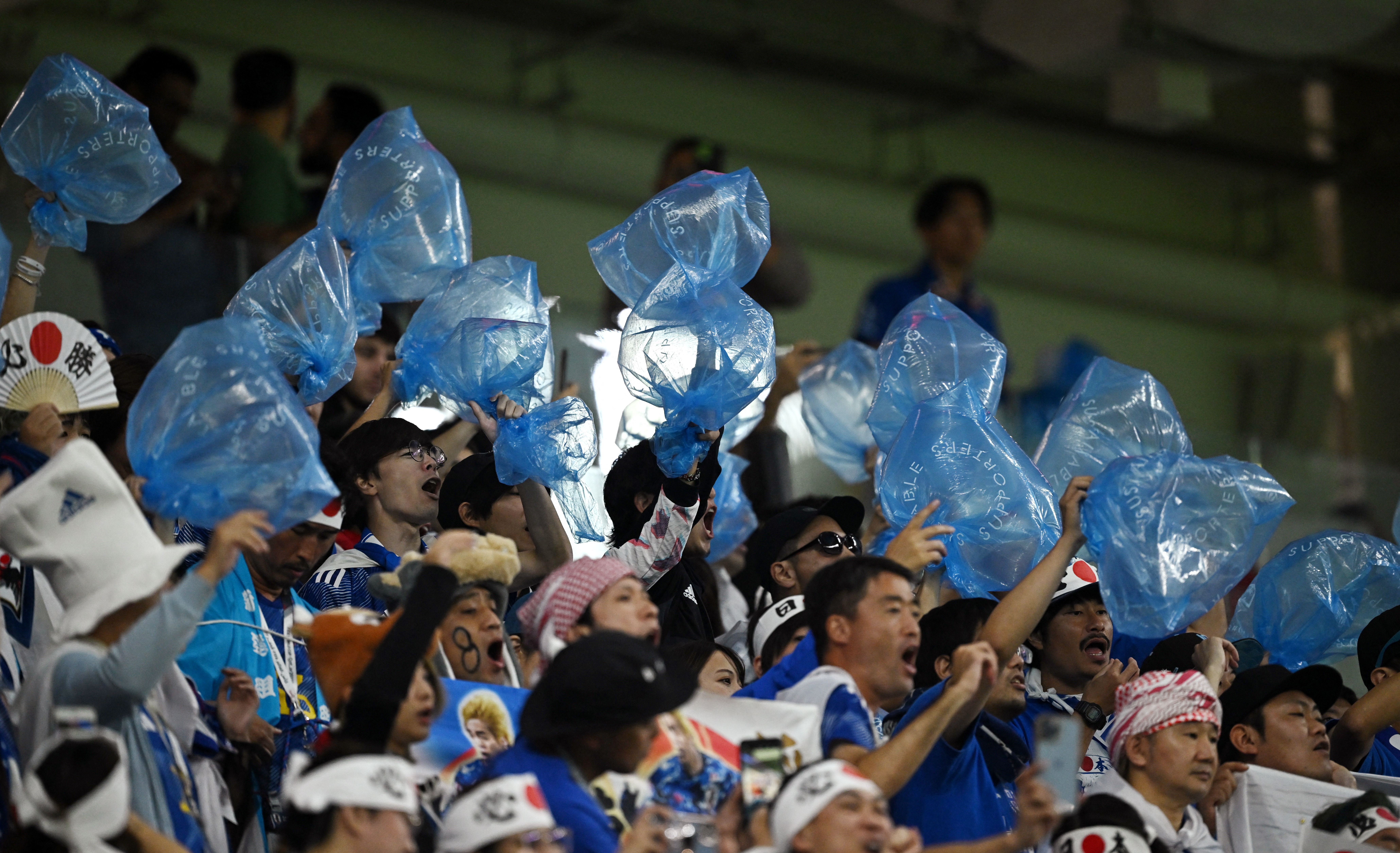 No son los "pituglobos" de cancha, son las bolsas de basura que después usan los japoneses para recoger residuos (REUTERS/Dylan Martinez)