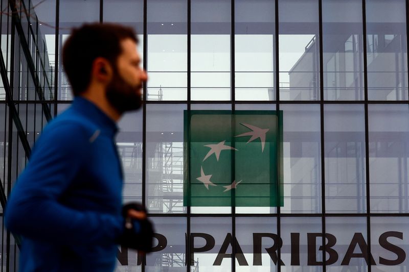 FILE FOTO: Un uomo passa davanti al logo della banca BNP Paribas sull'edificio della banca a Issy-les-Moulineaux, Francia.  REUTERS/Gonzalo Fuentes