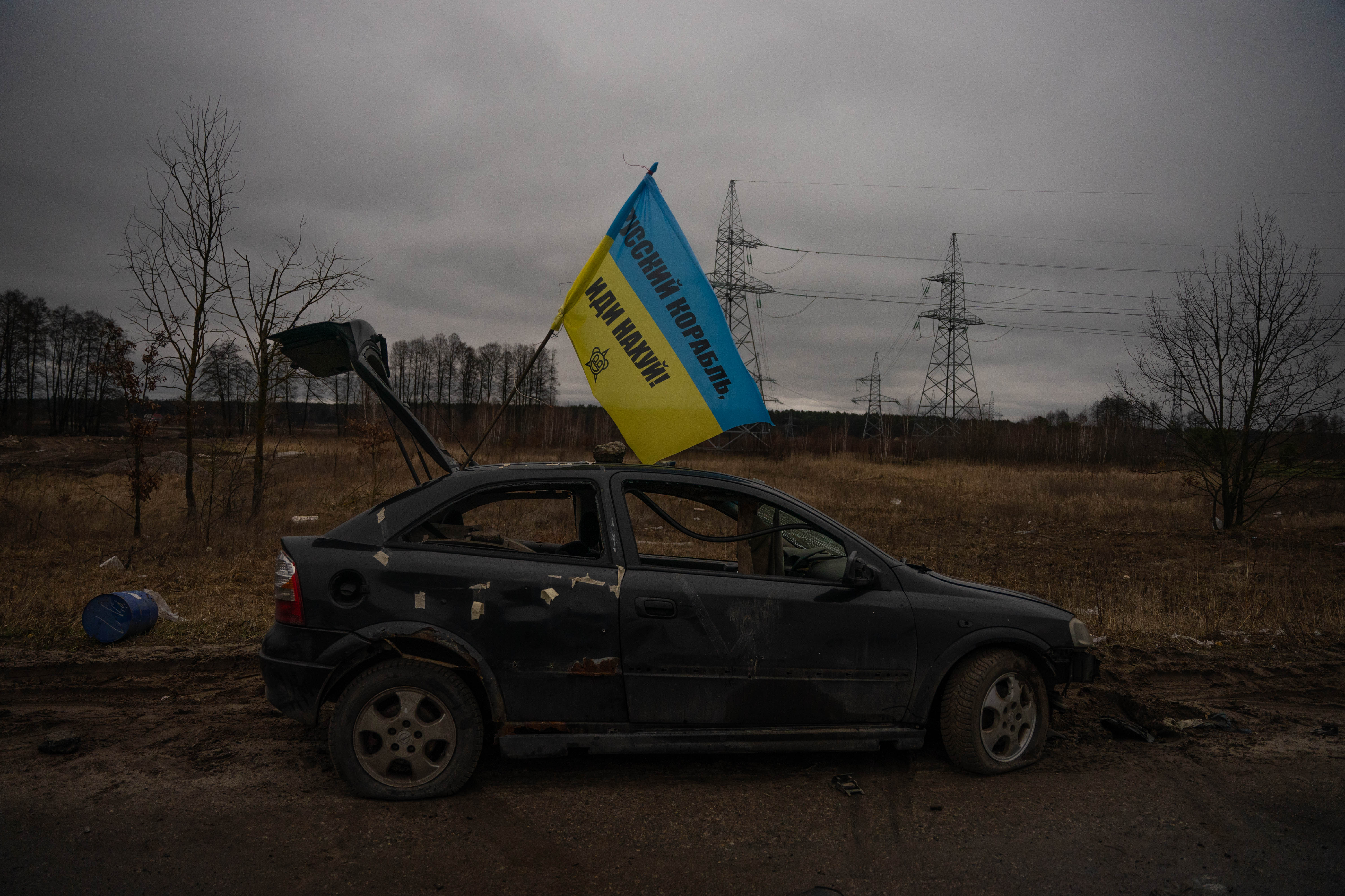 En el último checkpoint antes de dejar Irpin, un auto destruido con una bandera ucraniana flameando y una insignia escrita en ella: “Barco ruso, vete a la mierda”.