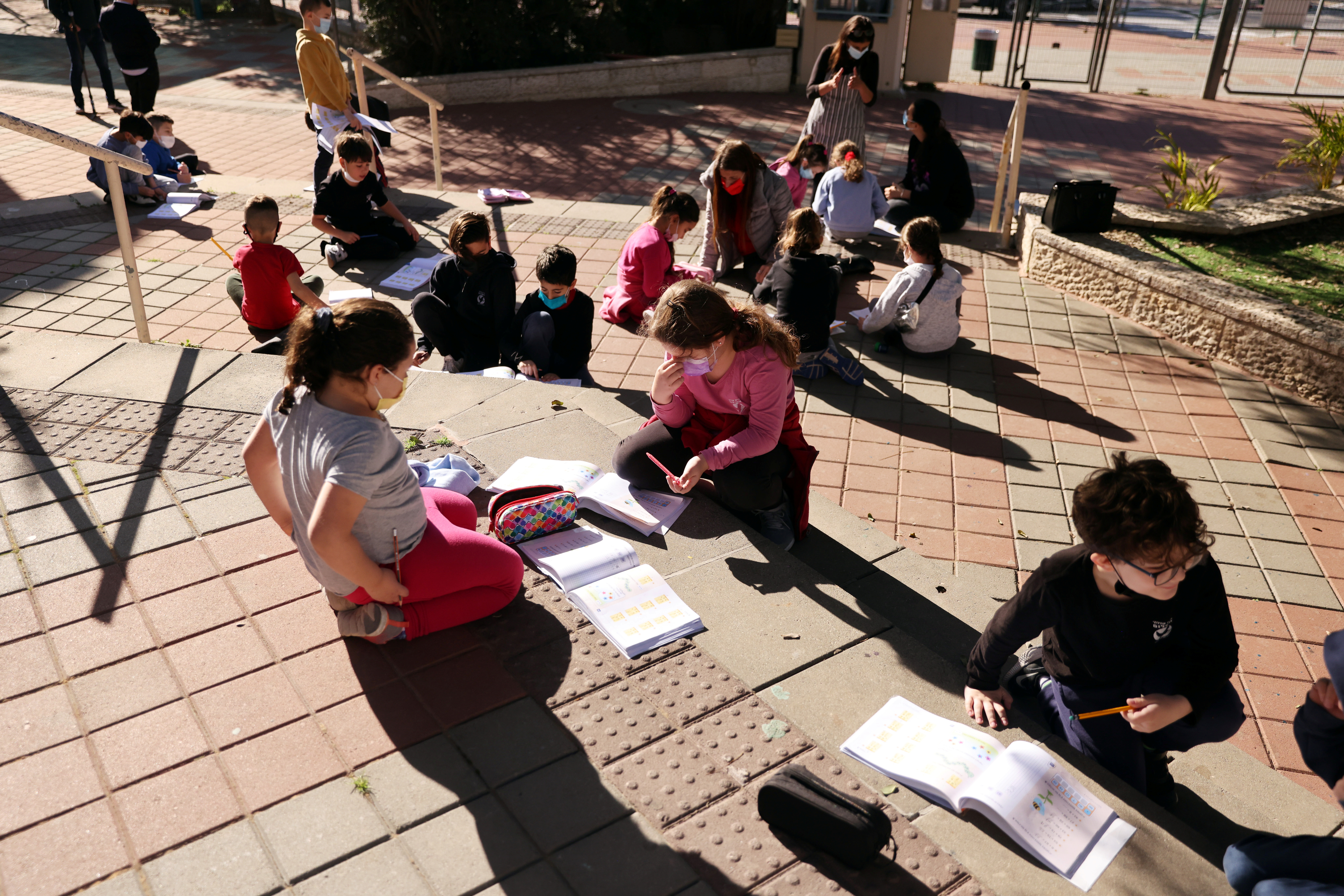 Niños estudian en el patio de su escuela en Mevaseret Zion, después de que Israel aliviara algunas restricciones  (REUTERS/ Ronen Zvulun)