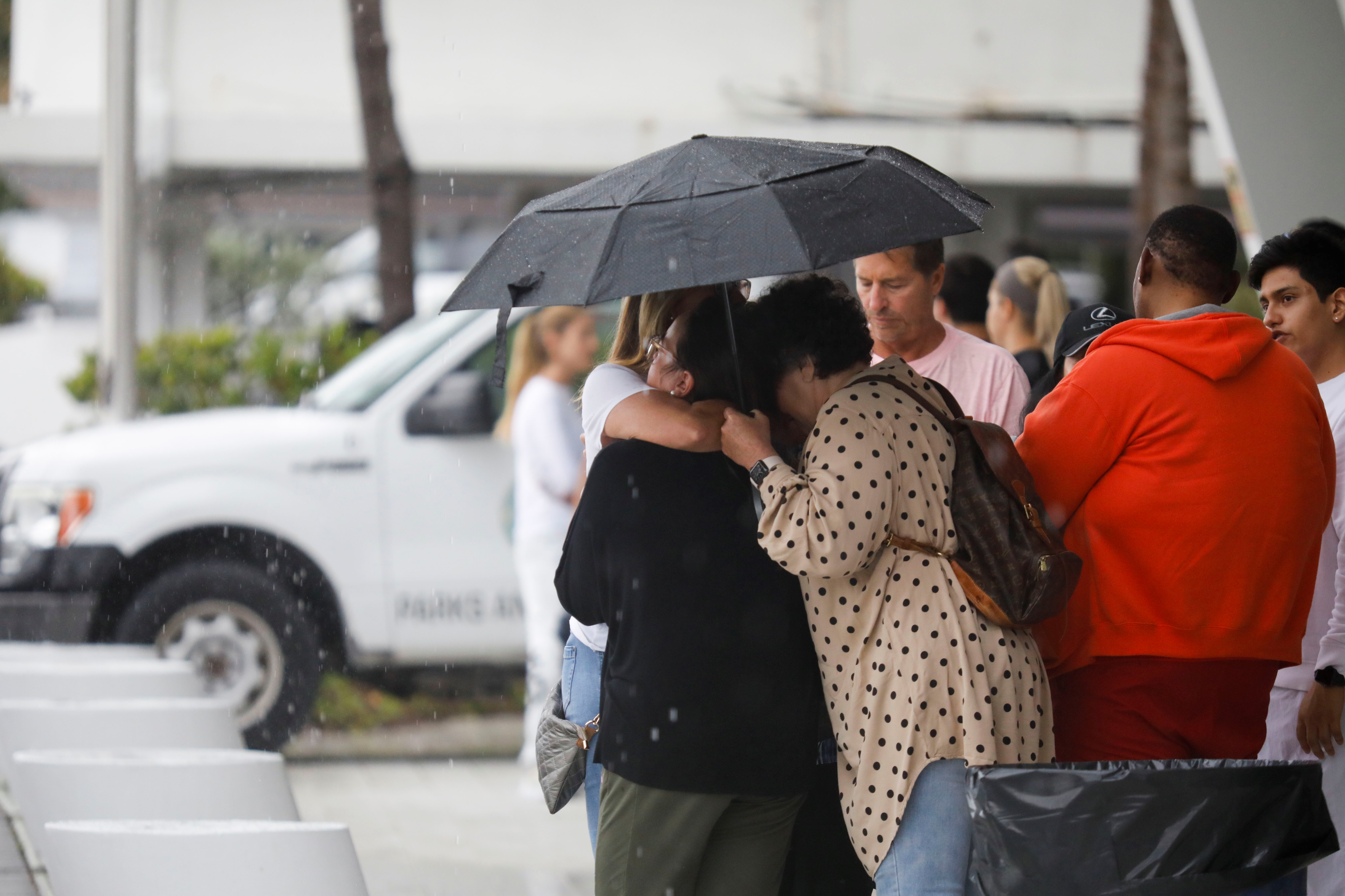 Personas se dan apoyo tras el colapso del edificio en Miami