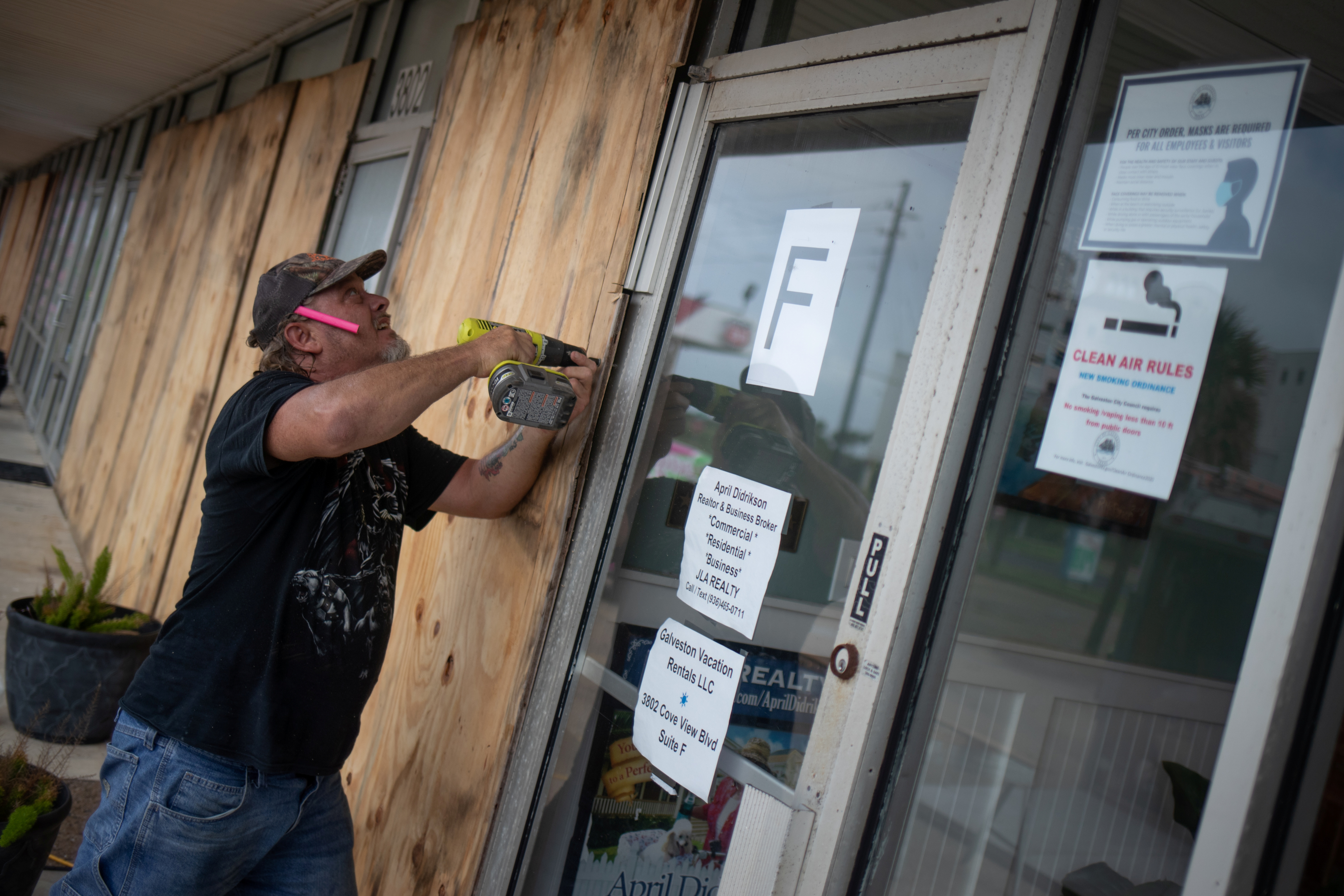 Un residente de Galveston, Texas, protege un comercio ante la llegada del huracán este 26 de agosto de 2020. REUTERS/Adrees Latif