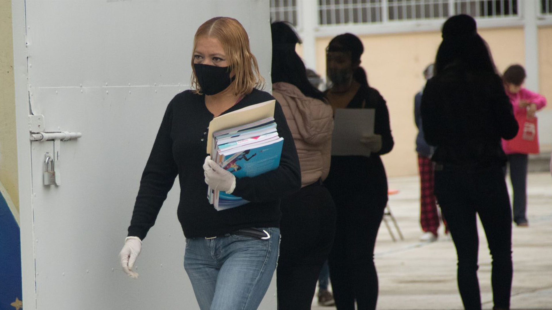 Una madre de familia se retira de la escuela después de haber recogido los libros de texto gratuito (Foto: Cuartoscuro)