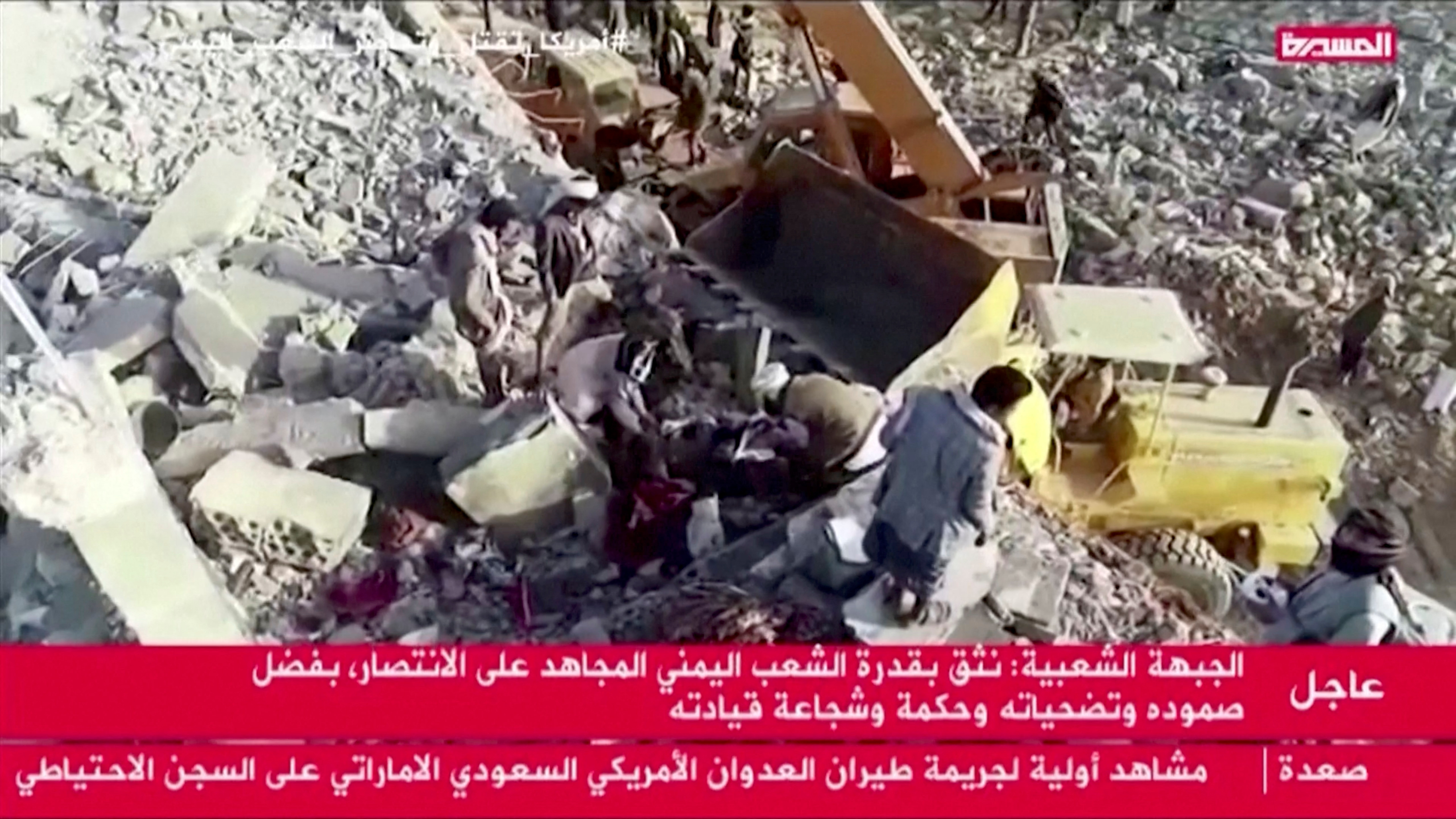 Los trabajadores de rescate sacan un cuerpo de entre los escombros después de que un ataque aéreo impactara contra un centro de detención temporal en Saada, Yemen, el 21 de enero de 2022, en esta imagen fija obtenida de un vídeo. Vídeo grabado con un dron. Al Masirah TV/REUTERS TV vía REUTERS 