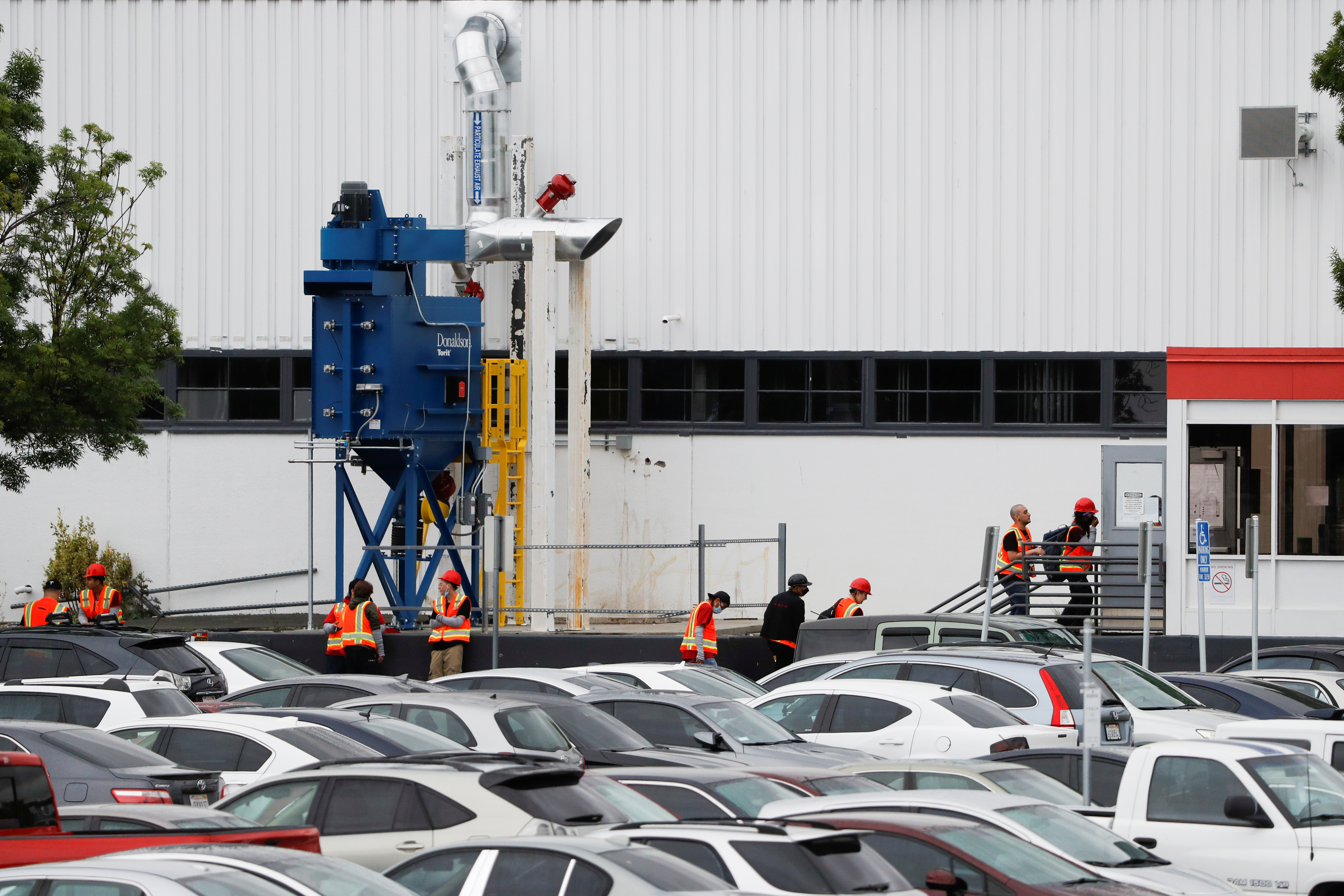 Empleados de Tesla entran a la planta de Fremont este martes 12 de mayo, después de que Elon Musk decidiera violar la cuarentena. (Reuters)