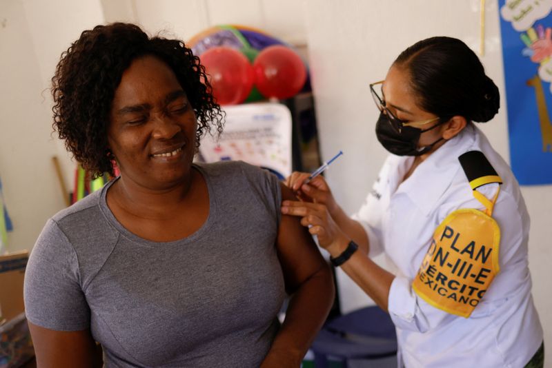 Una migrante procedente de Haití que intenta entrar en Estados Unidos junto a su marido, recibe una dosis de la vacuna de COVID-19 en Ciudad Juárez (Foto: Reuters)