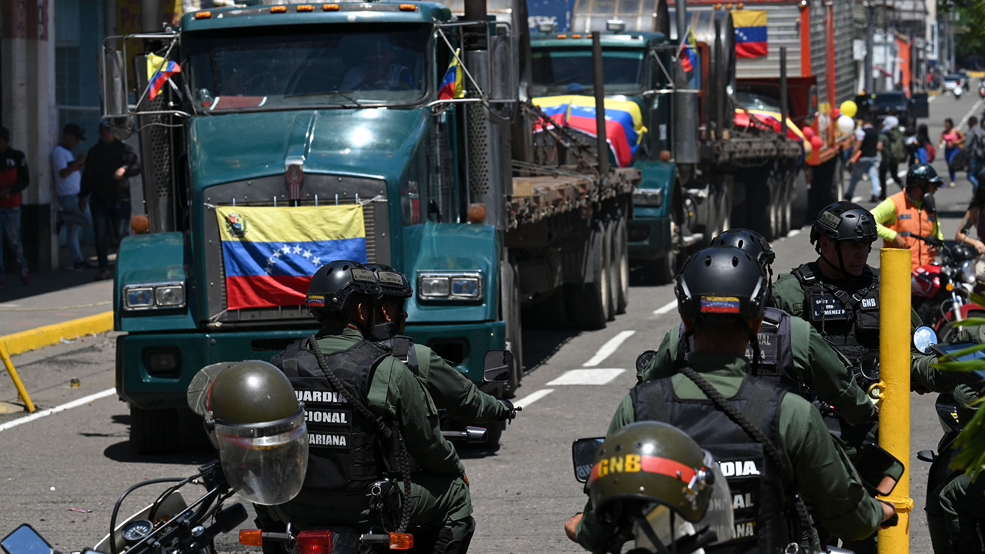 Efectivos de la Guardia Nacional Bolivariana de Venezuela esperan el arribo de los pocos camiones que pasaron (AFP)