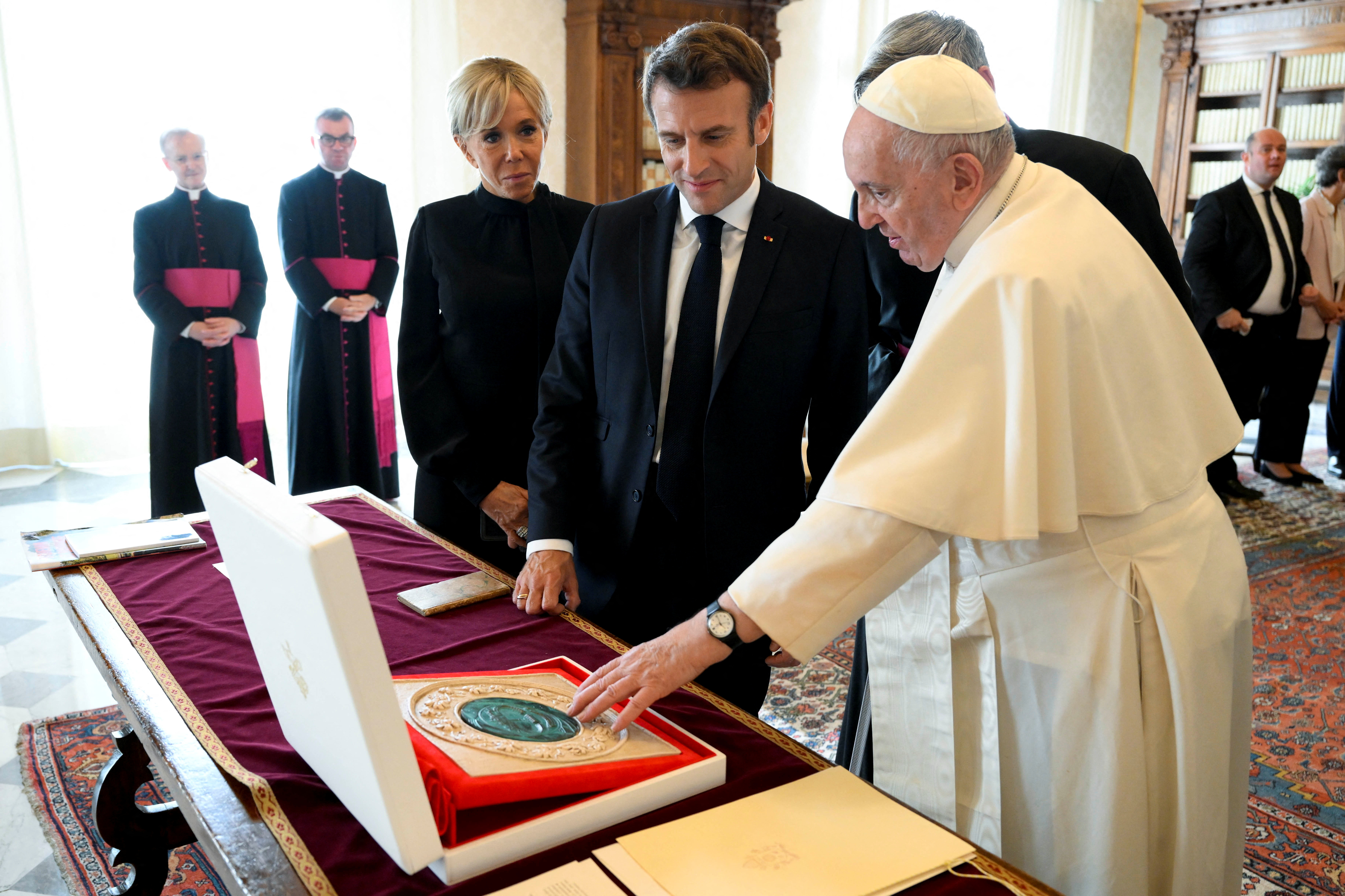 El Papa le obsequió al presidente francés una medalla de bronce, enmarcada en mármol, que representa a San Pedro y la columnata del arquitecto barroco Gian Loreznzo Bernini.  (Vatican Media/REUTERS)