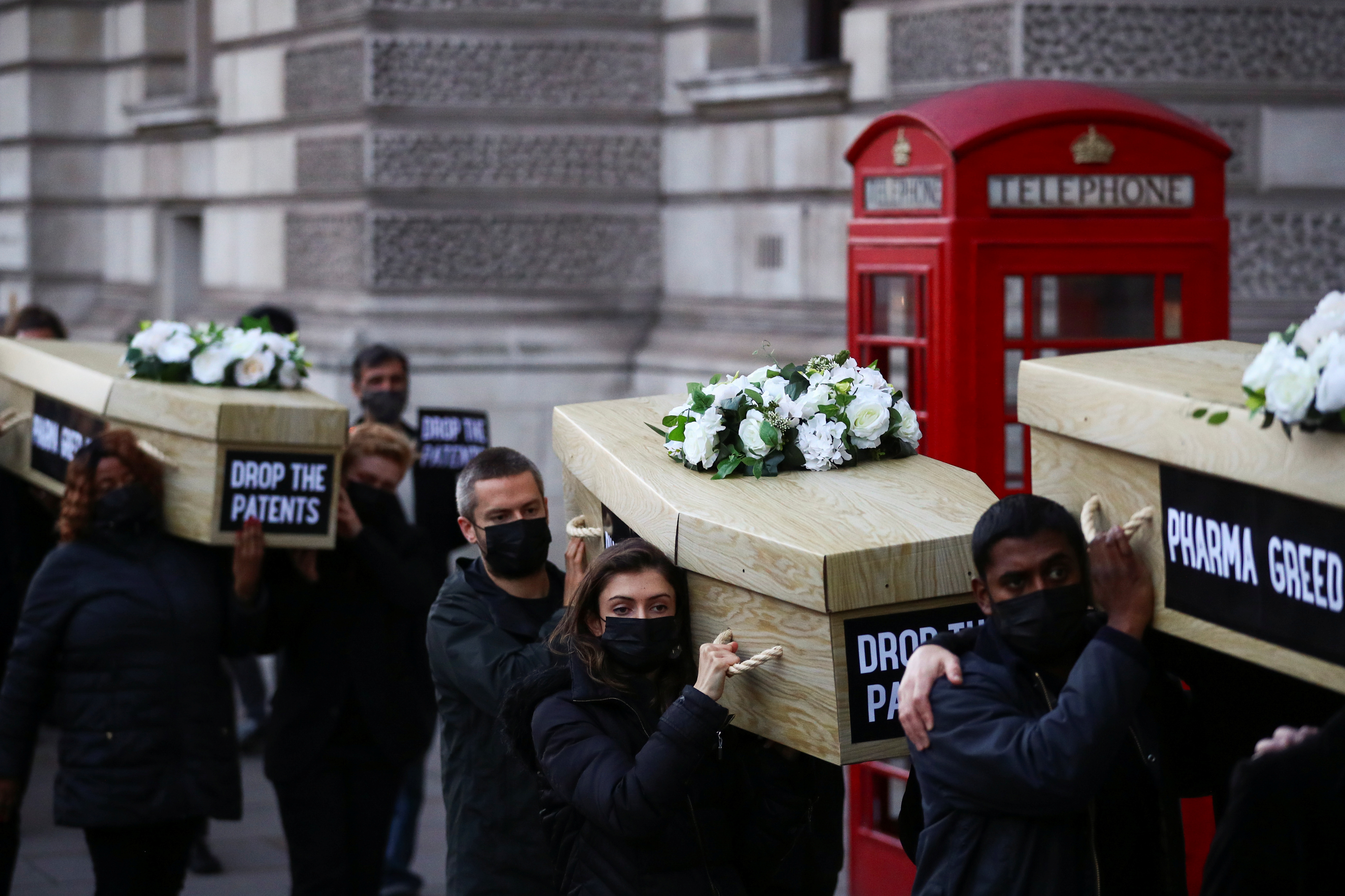 Miembros de Global Justice Now protestan llevando ataúdes por Westminster para remarcar el número global de muertes por la enfermedad del coronavirus (COVID-19), en Londres, Gran Bretaña el 12 de octubre de 2021. REUTERS/Hannah McKay