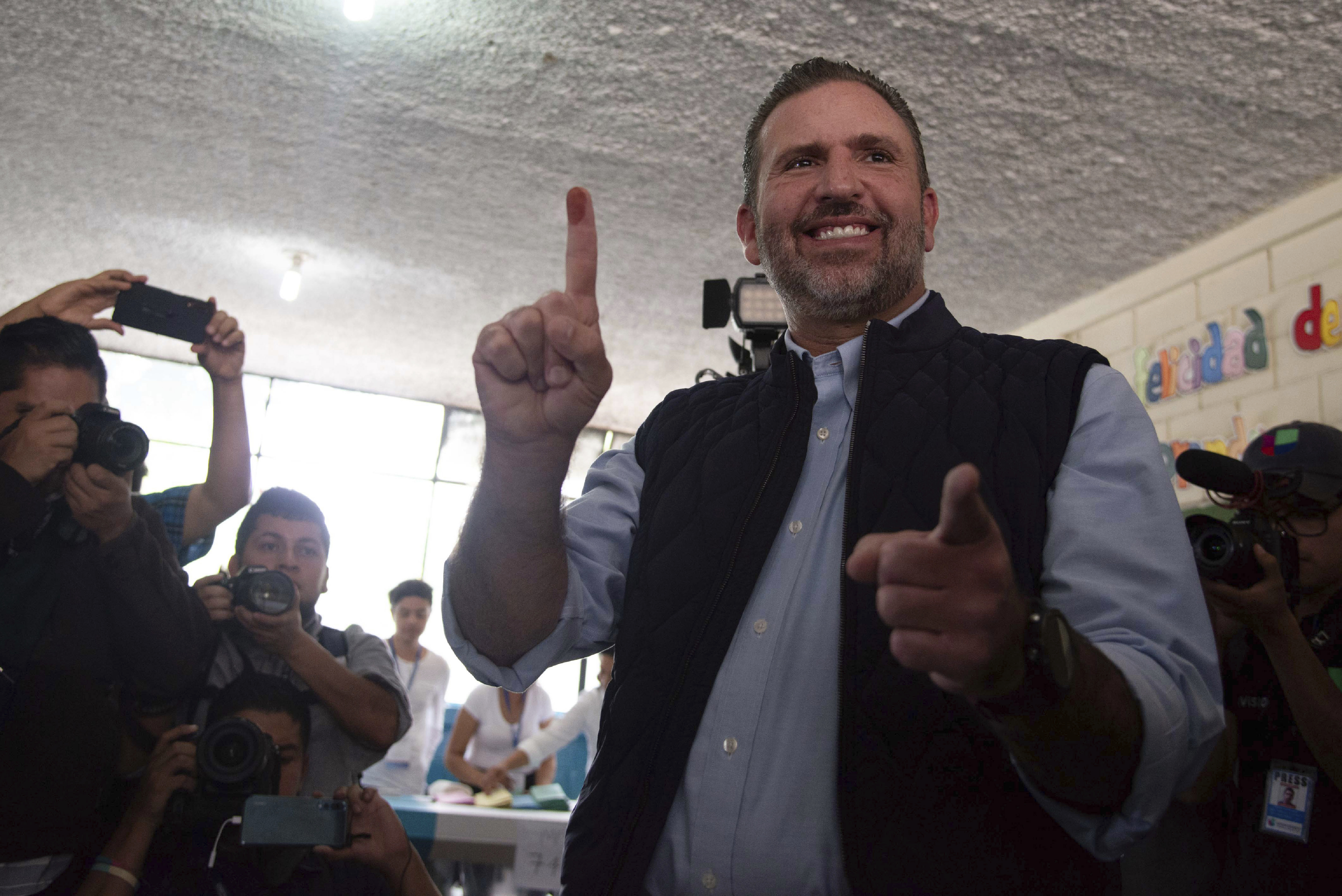 ARCHIVO - Roberto Arzú, candidato presidencial del partido Podemos, muestra su dedo manchado de tinta después de votar en las elecciones generales en Ciudad de Guatemala, el 16 de junio de 2019. La Corte de Constitucionalidad informó el jueves 25 de mayo de 2023 que rechazó tres recursos de apelación presentados por Arzú, a quien el Tribunal Supremo Electoral le había anulado su candidatura por considerar que realizó una campaña anticipada, con lo cual el aspirante queda fuera de la carrera presidencial. (AP Foto/Santiago Billy, Archivo)