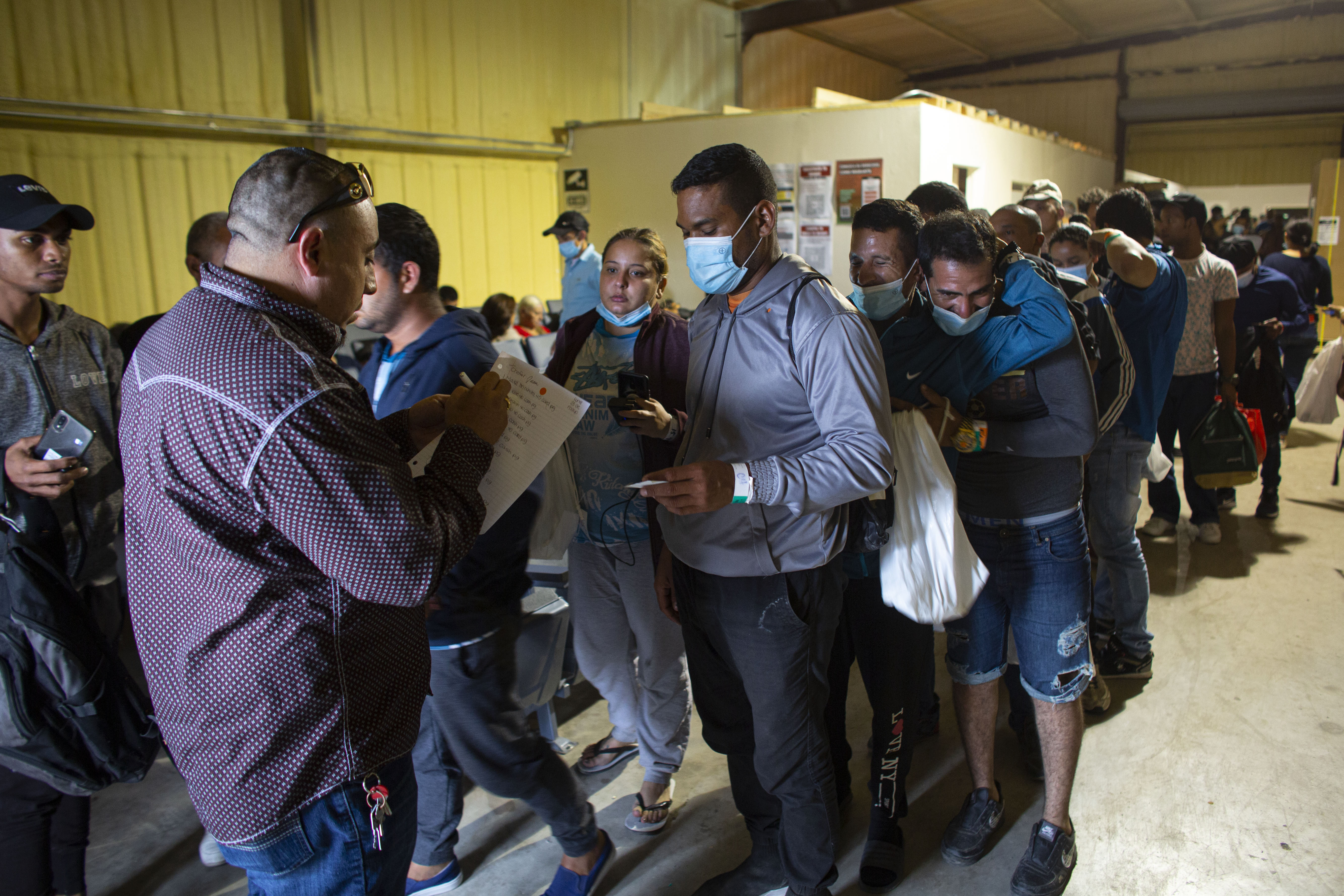 Varias personas hacen fila para abordar un autobús que los llevará al aeropuerto de San Antonio (AP Foto/Darío López-Mills/Archivo)