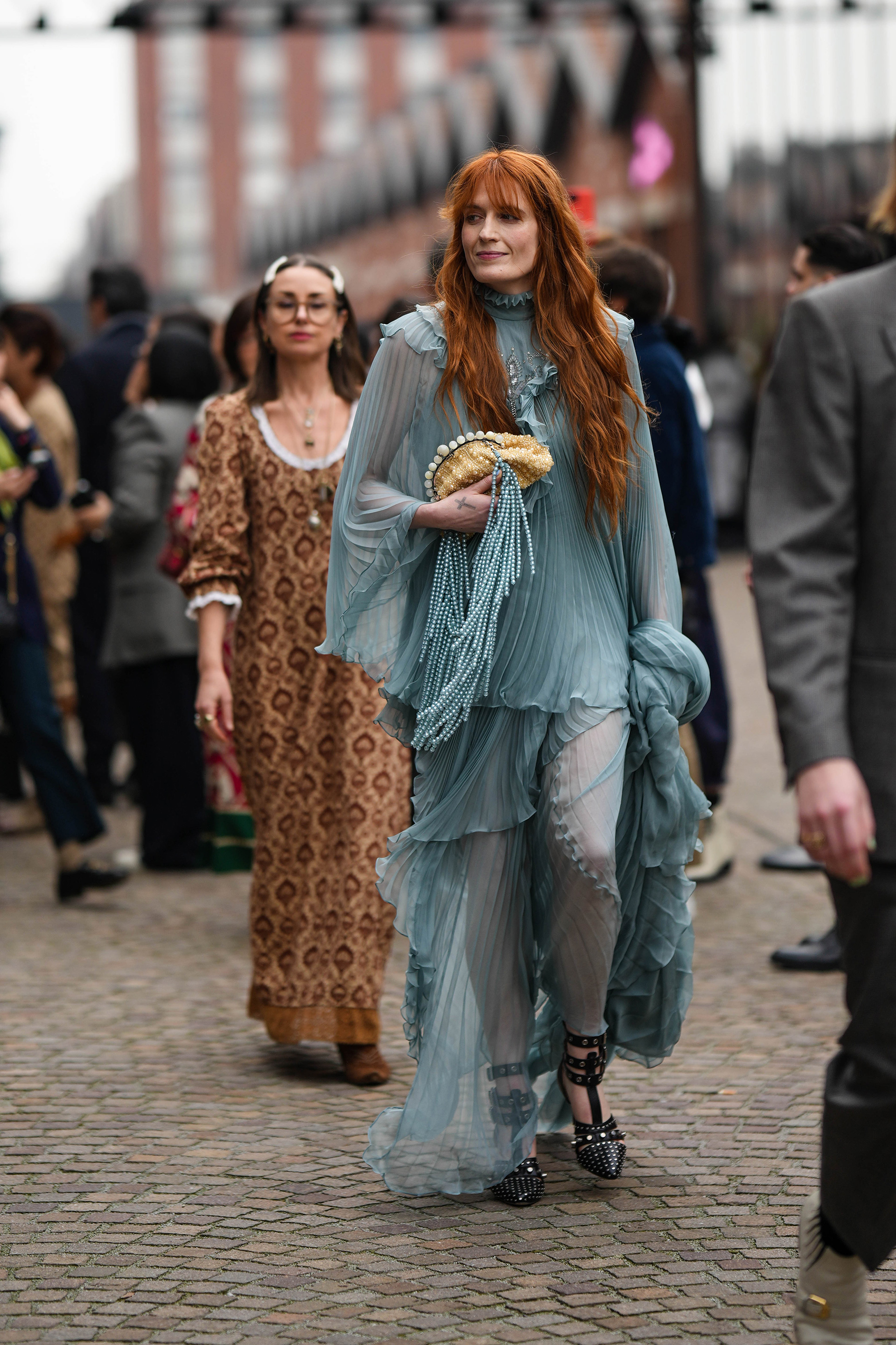 Florence Welch lució un estilo boho chic con un vestido gris de gasa plisada y cola vaporosa en el desfile de Gucci en la Semana de la Moda de Milán