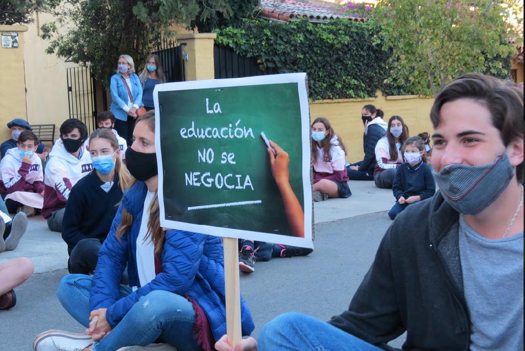 "La educación no se negocia", se lee en uno de los carteles que sostiene una alumna bonaerense que participó de una sentada frente a su colegio