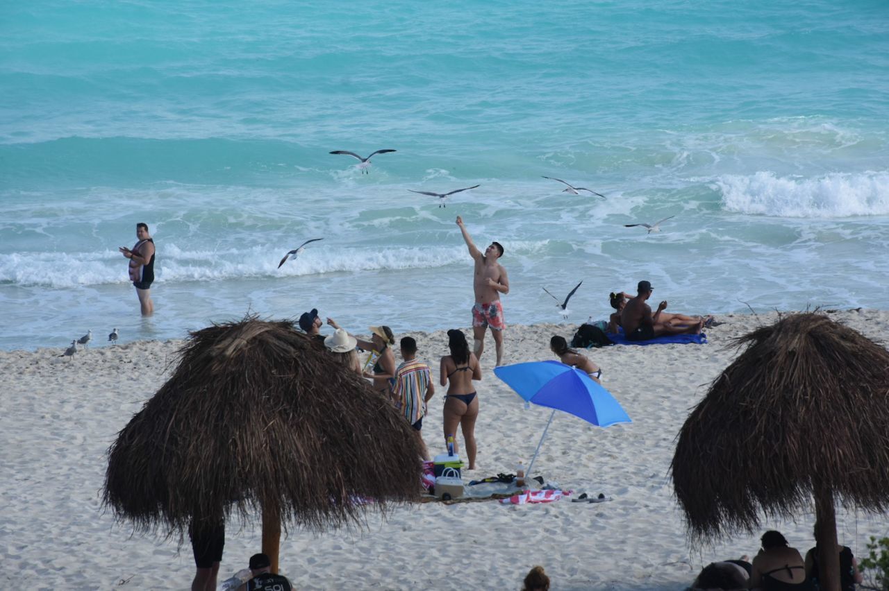 CANCÚN, QUINTANA ROO, 23DICIEMBRE2020.- Cientos de turistas nacionales y extranjeros arriban a las playas del caribe mexicano durante la temporada navideña a pesar de la pandemia por Covid-19. La entidad se mantiene en semáforo amarillo por Covid-19. A pesar que el límite establecido de ocupación hotelera por el color del semáforo es del 60% por ciento, el gobierno del estado ha otorgado permisos especiales para que los establecimientos lleguen hasta el 80%. durante el periodo del 21 al 27 de diciembre a aquellas empresas certificadas con las medidas sanitarias correspondientes. FOTO: ELIZABETH RUIZ/CUARTOSCURO.COM