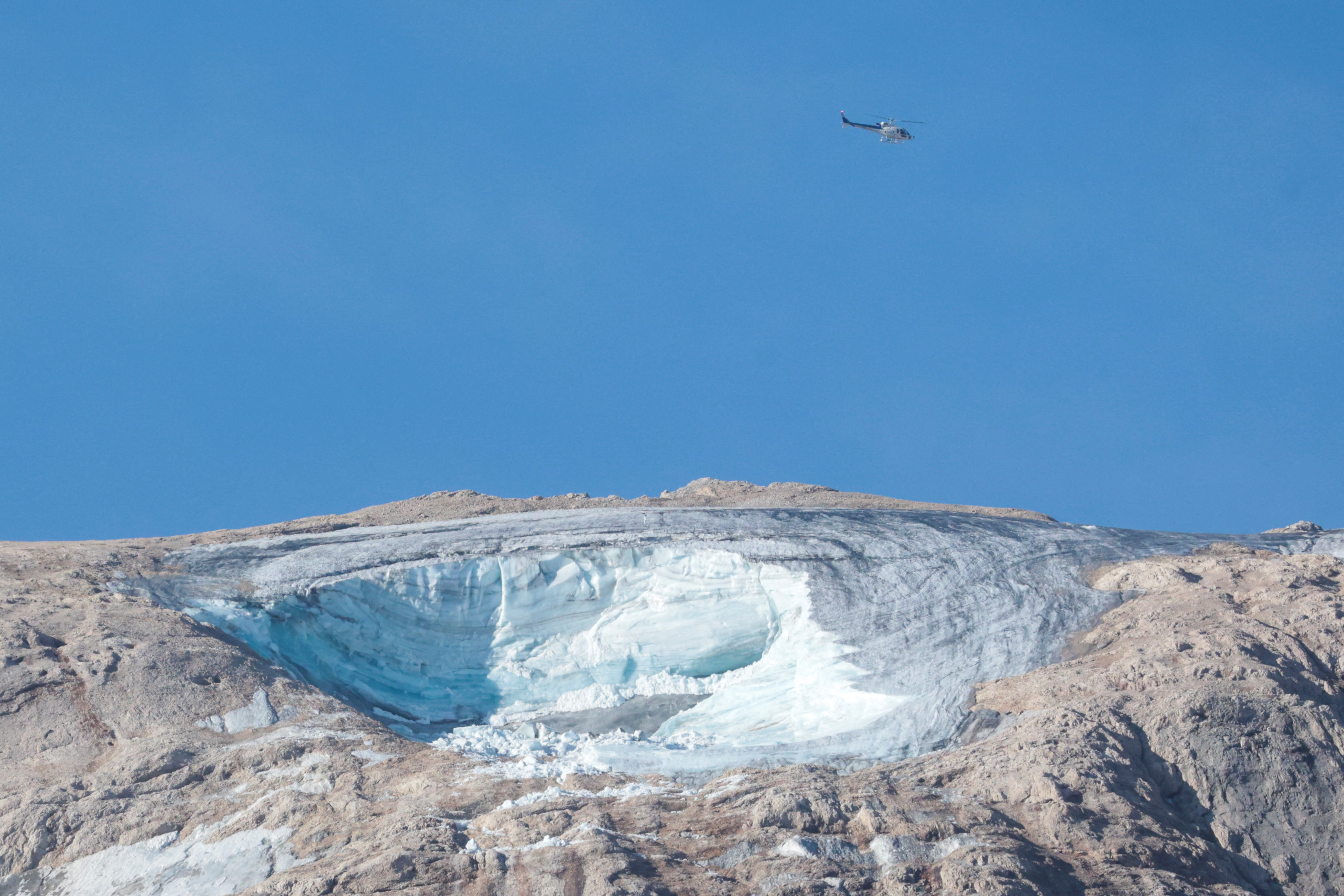 Un helicóptero sobrevuela Punta Rocca, la cima de la Marmolada donde colapsó el glaciar (REUTERS/Borut Zivulovic)