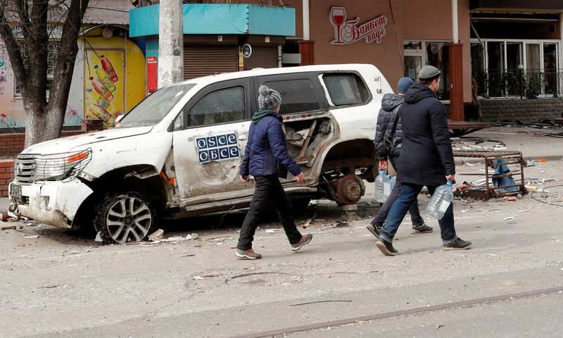 Imagen de archivo de gente pasando junto a un auto dañado de la OSCE en Mariúpol, Ucrania. 1 abril 2022. REUTERS/Alexander Ermochenko