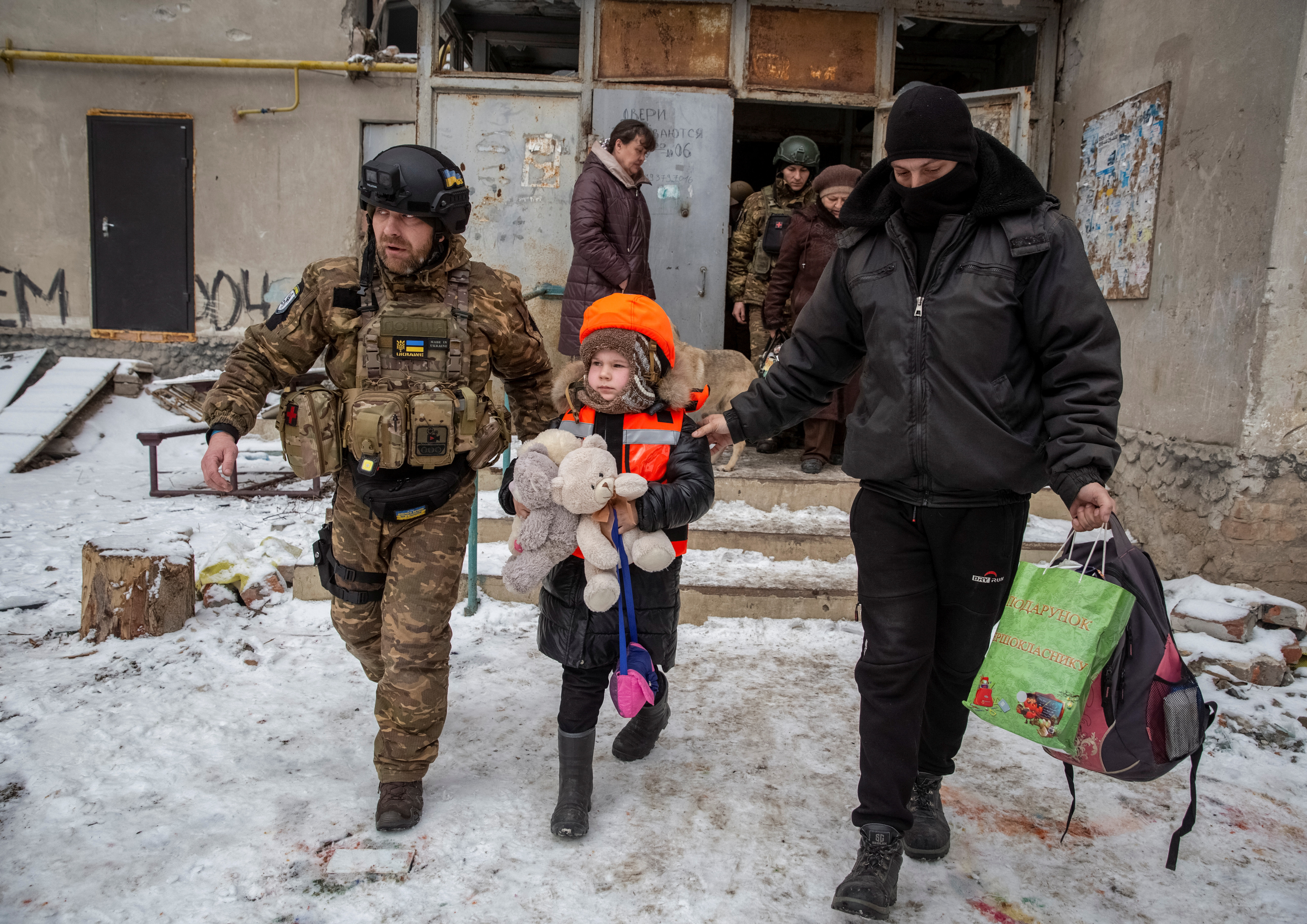 Los policías ayudan a Arina, de 6 años, vestida con chaleco antibalas y casco para niños durante su evacuación de la ciudad de primera línea de Bakhmut, en medio del ataque de Rusia a Ucrania, en la región de Donetsk, Ucrania