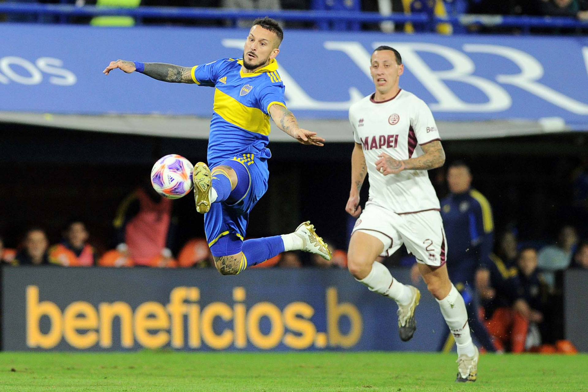 El Pipa Benedetto intenta controlar el balón ante la mirada de Cristian Lema (Télam)