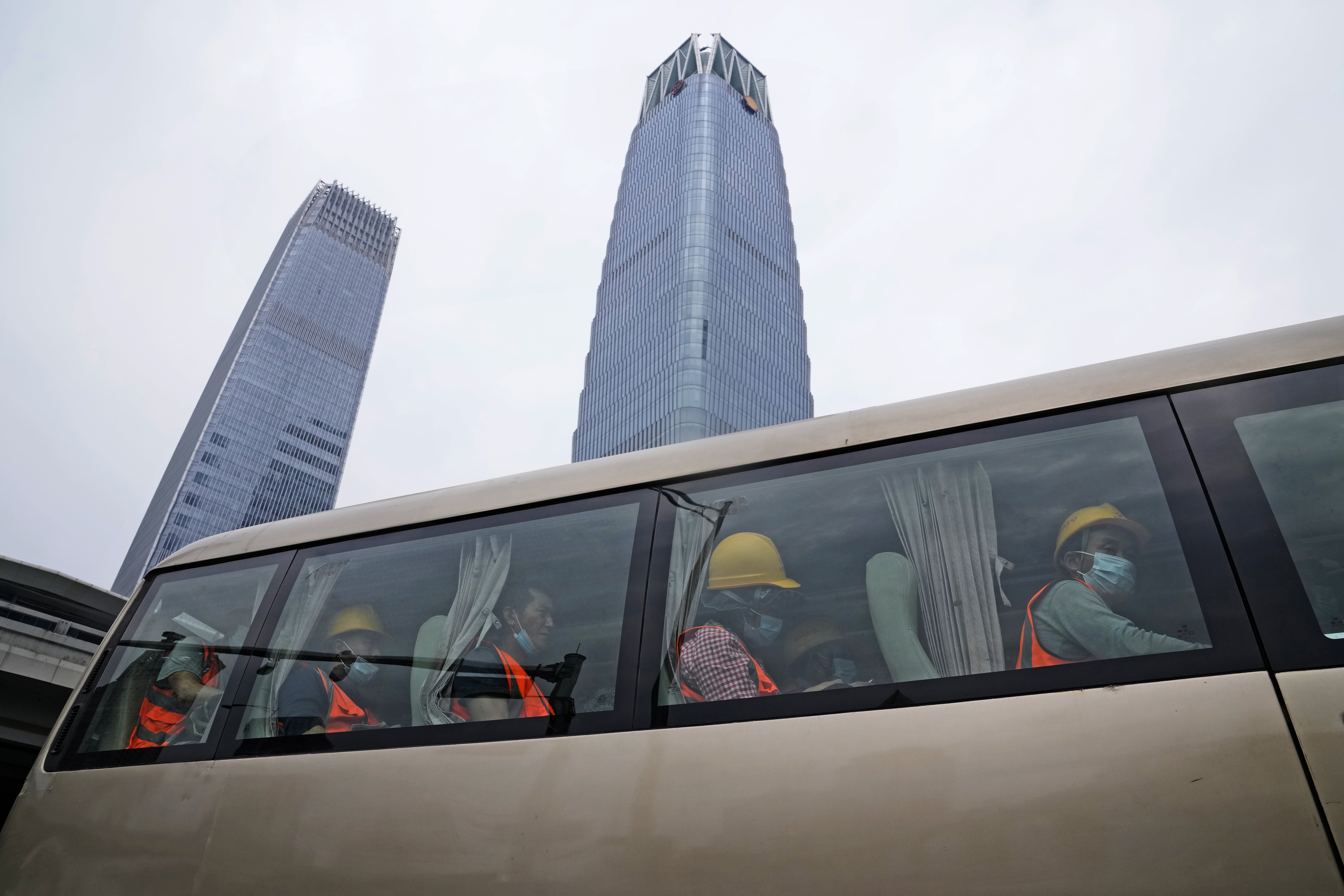 Trabajadores con máscaras llegan a un lugar de trabajo cerca de rascacielos en el Distrito Central de Negocios, el lunes 27 de junio de 2022, en Beijing. (Foto AP/Ng Han Guan)