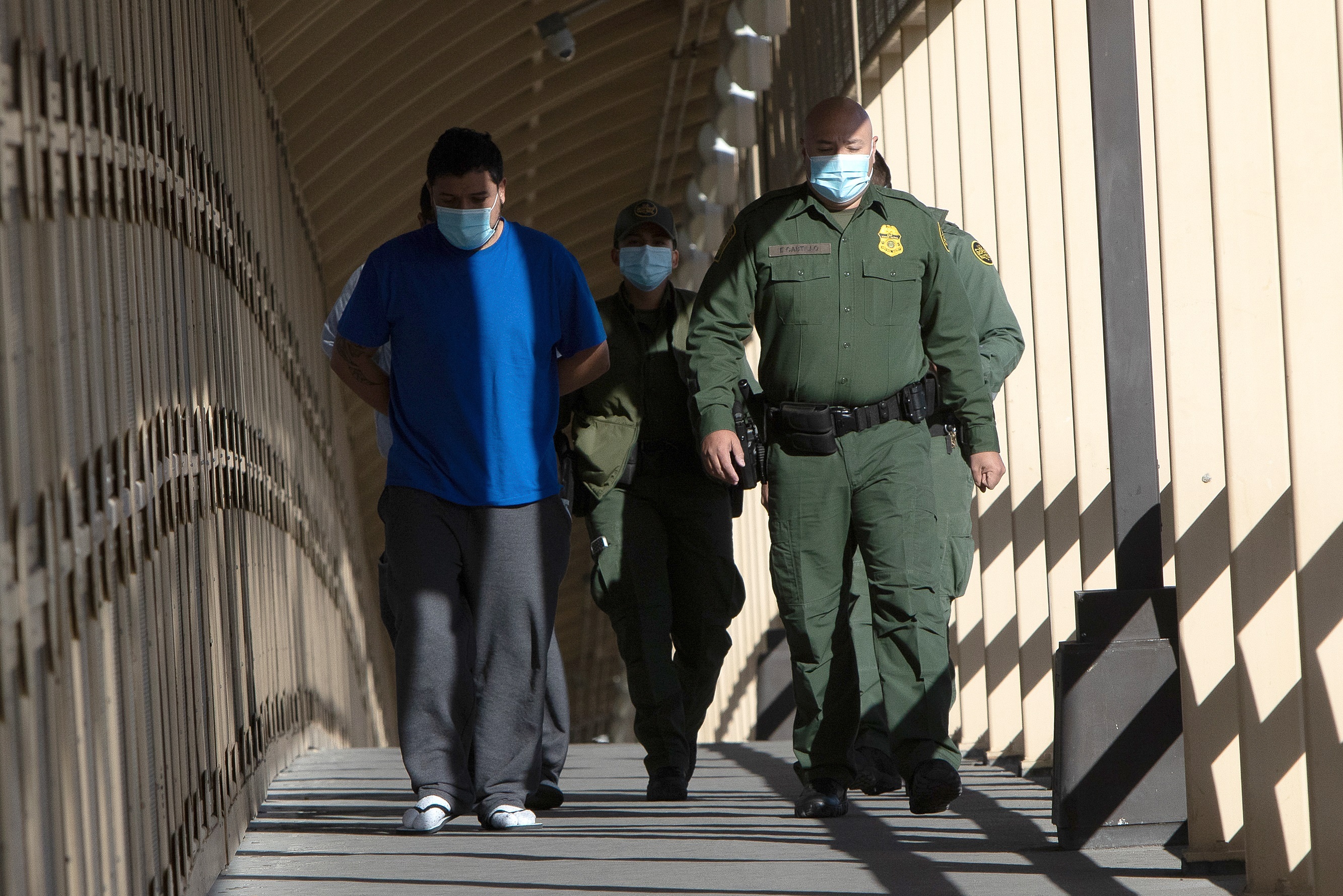 Dos migrantes centroamericanos (i) caminan mientras son deportados bajo el programa reactivado "Quédate en México" por el puente Internacional Reforma, hoy, en Ciudad Juárez, estado de Chihuahua (México). EFE/ Luis Torres
