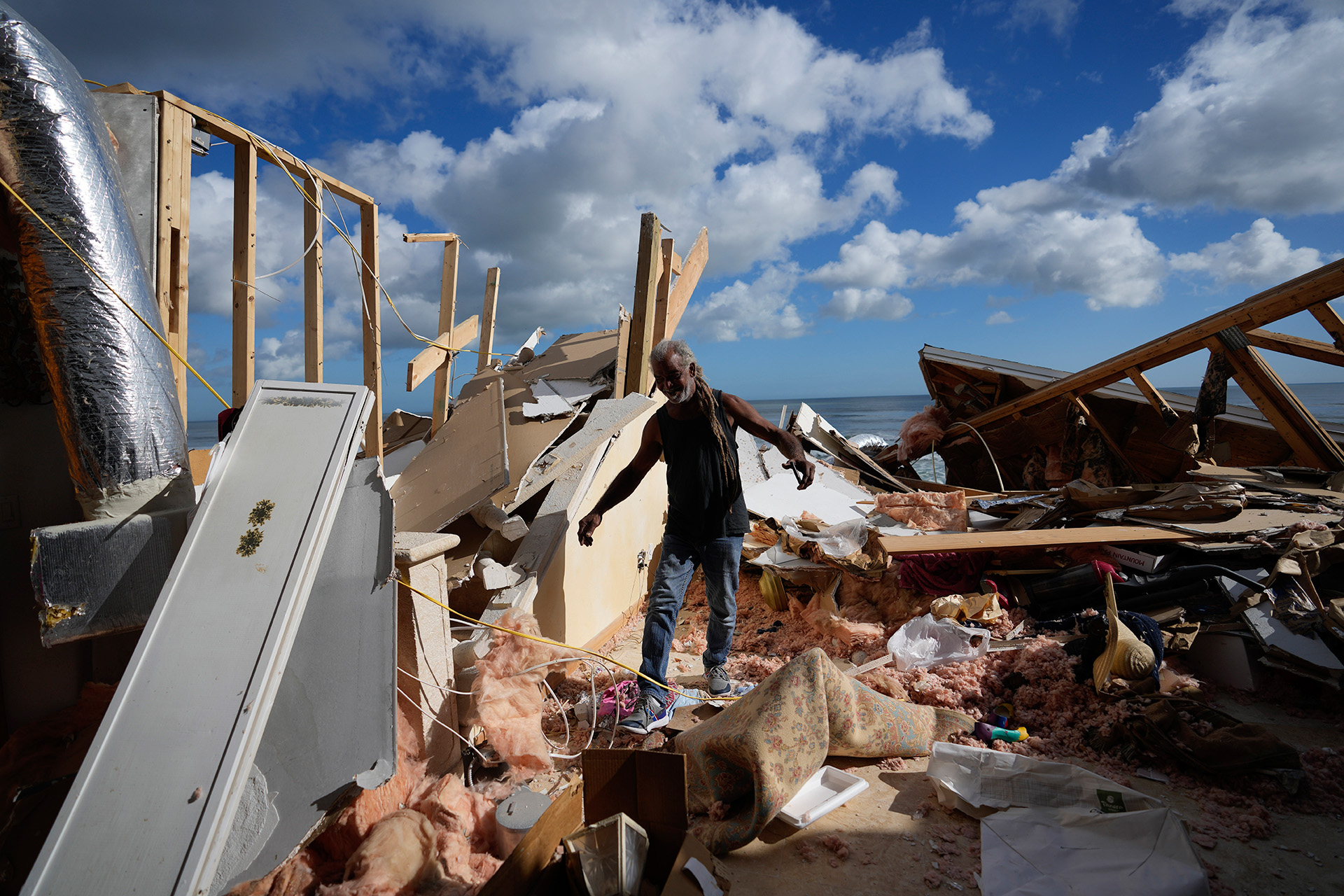 Un hombre camina sobre los restos de una casa después de que la mitad se derrumbara tras la erosión de la playa por el huracán Nicole, el 12 de noviembre de 2022, en Wilbur-By-The- Sea, Florida (Foto AP/Rebecca Blackwell, archivo) 
