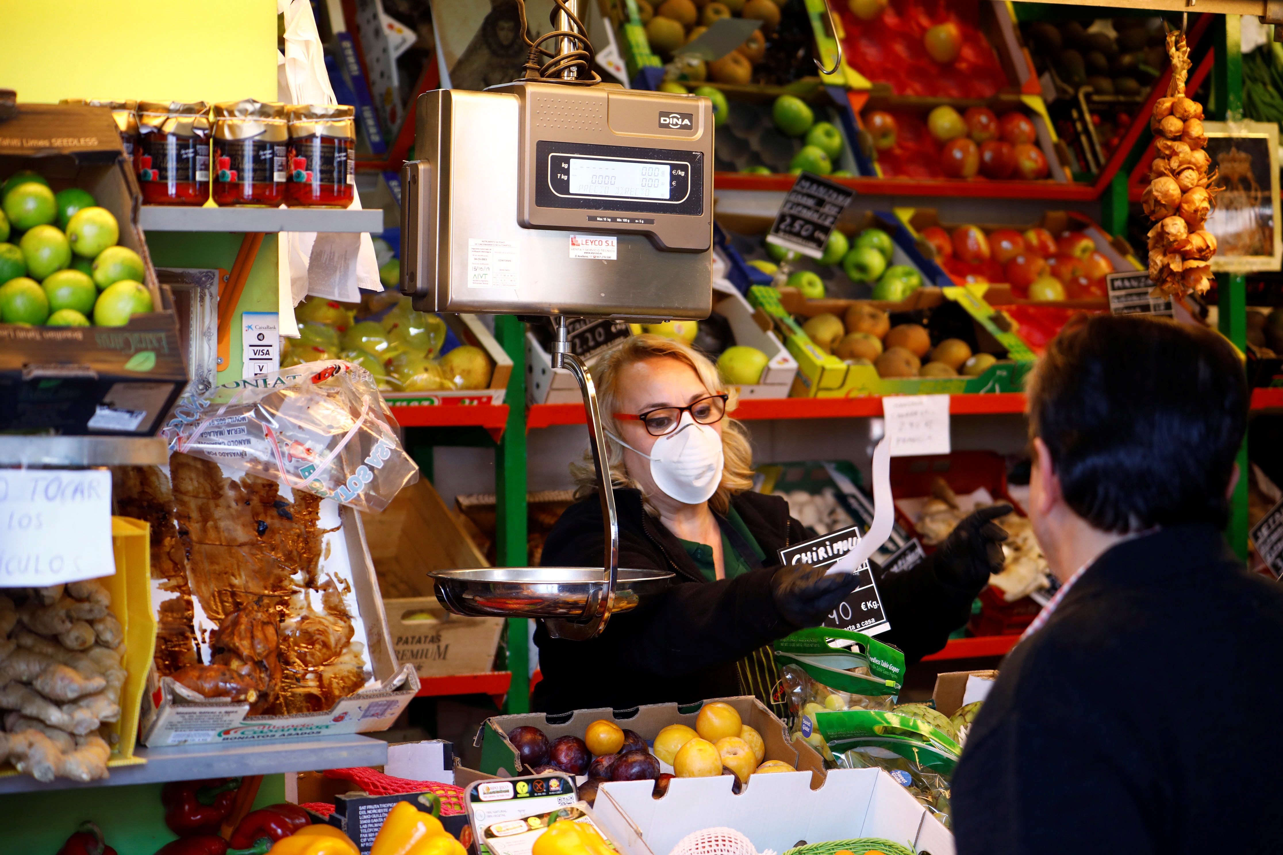 Una vendedora, protegida con mascarilla, trabaja en su puesto del mercado de abastos, en Córdoba. EFE/ Salas/Archivo