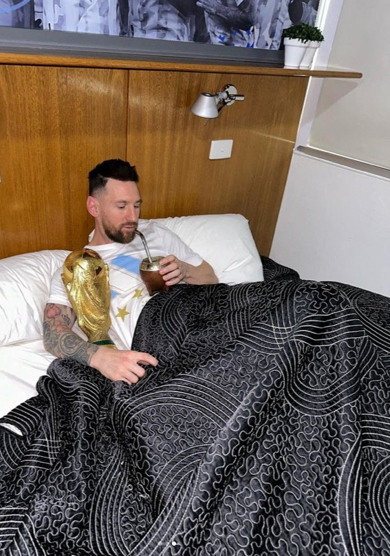 Argentina's Lionel Messi lies in bed with the FIFA World Cup trophy, at an unknown location, in this screenshot taken from social media and released on December 20, 2022. Instagram/leomessi/via REUTERS THIS IMAGE HAS BEEN SUPPLIED BY A THIRD PARTY. MANDATORY CREDIT. NO RESALES. NO ARCHIVES.