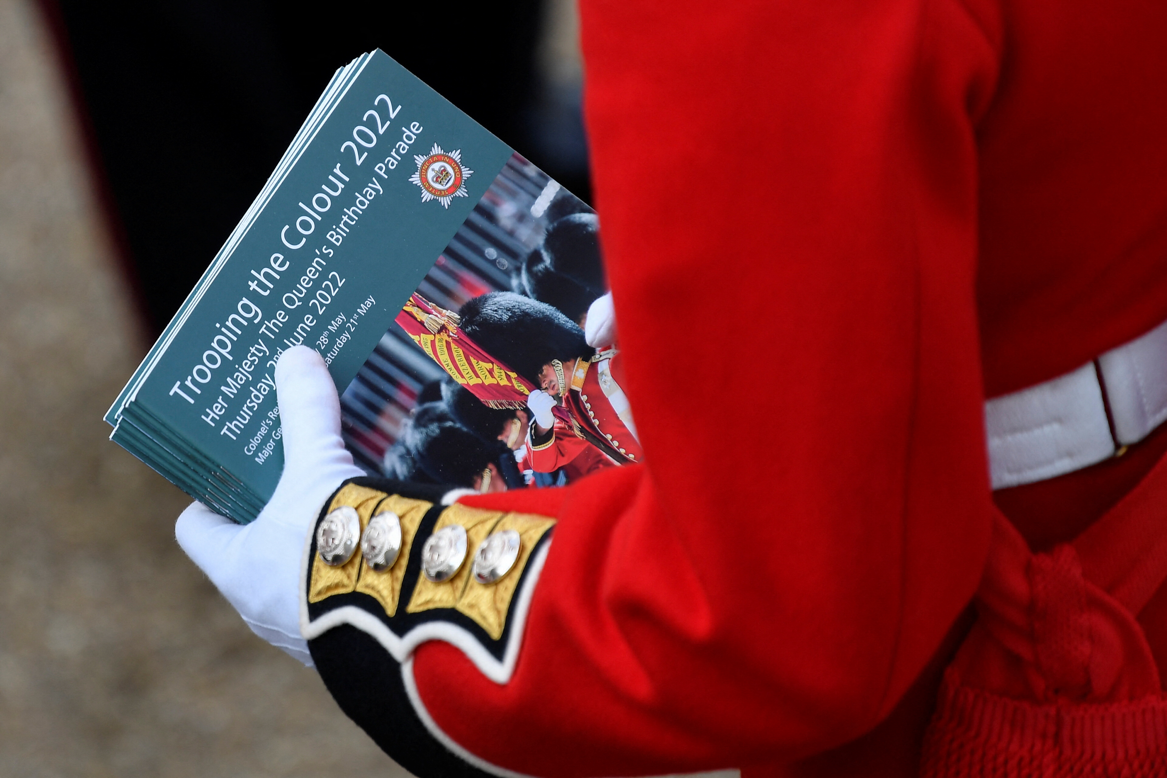 Un membro delle Coldstream Guards offre programmi di commemorazione alla parata Trooping the Colour.  REUTERS/Toby Melville/Piscina