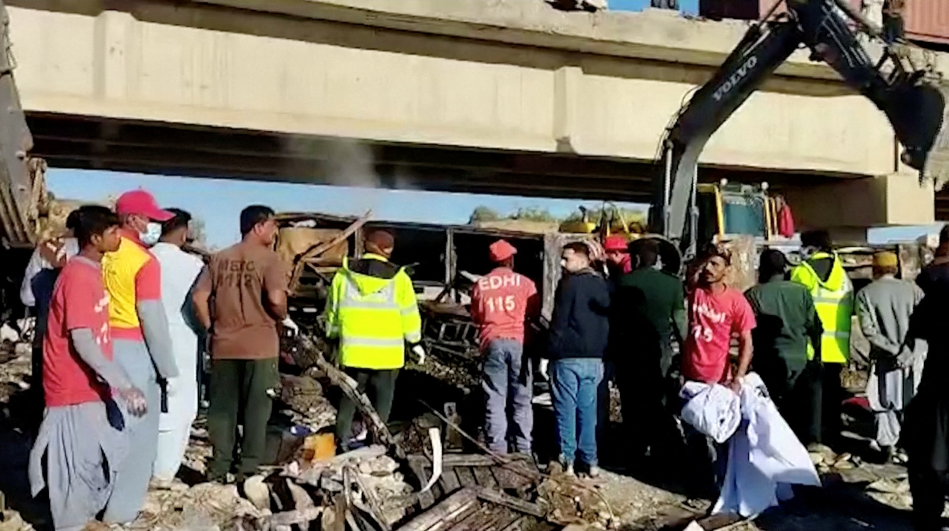 People work at the site of a bus crash in Lasbela District