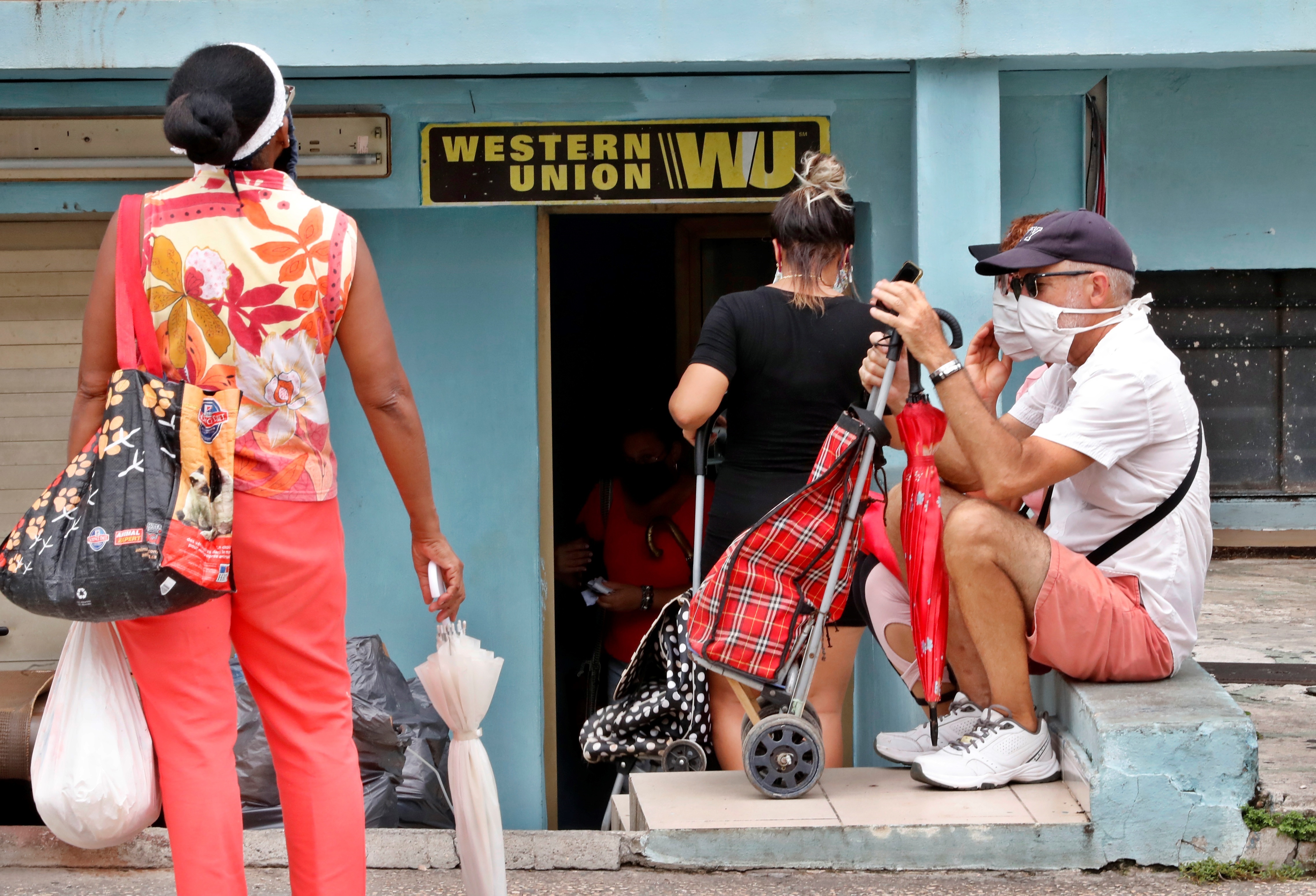 Varias personas esperan al frente de una oficina de Western Union, el pasado 4 de junio de 2020, en La Habana (Cuba). EFE/Ernesto Mastrascusa/Archivo
