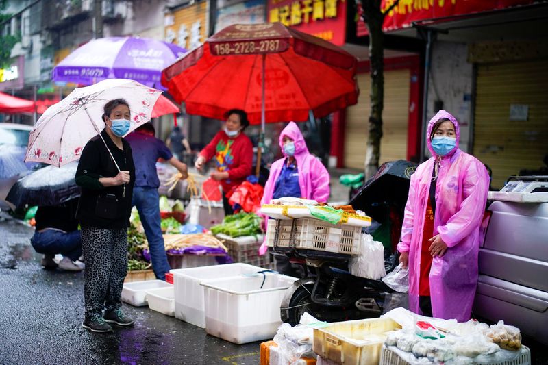 Varias personas con mascarillas en un mercado callejero en Wuhan, China (REUTERS/Aly Song)