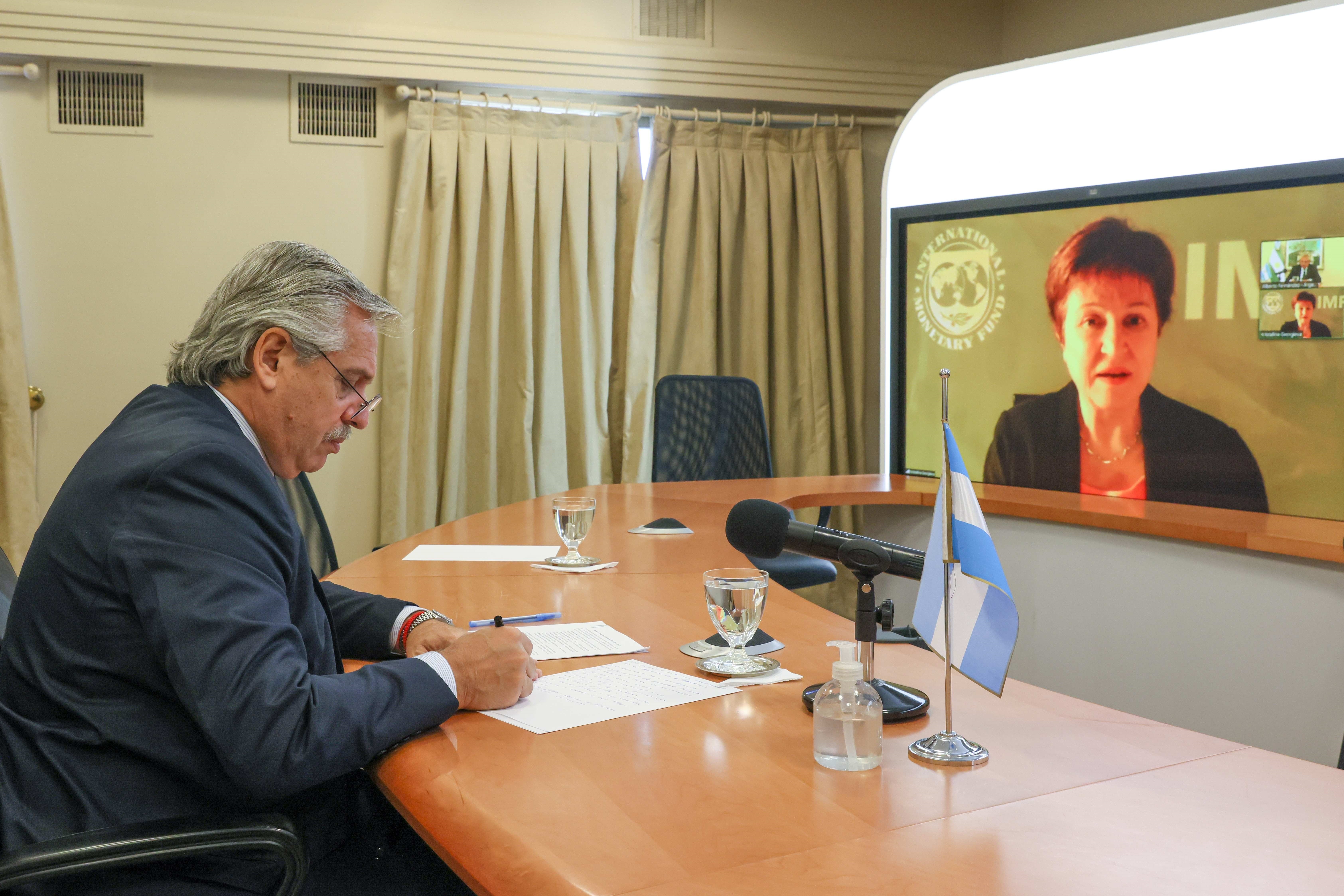 El 22 de marzo, Alberto Fernández anota mientras dialoga por videoconferencia con la directora directora gerente del Fondo Monetario Internacional (FMI), Kristalina Georgieva, en busca de  (Argentina). Ese día, la funcionaria del organismo internacional le aseguró la aprobación del nuevo programa con el Fondo (EFE/Esteban Collozo)
