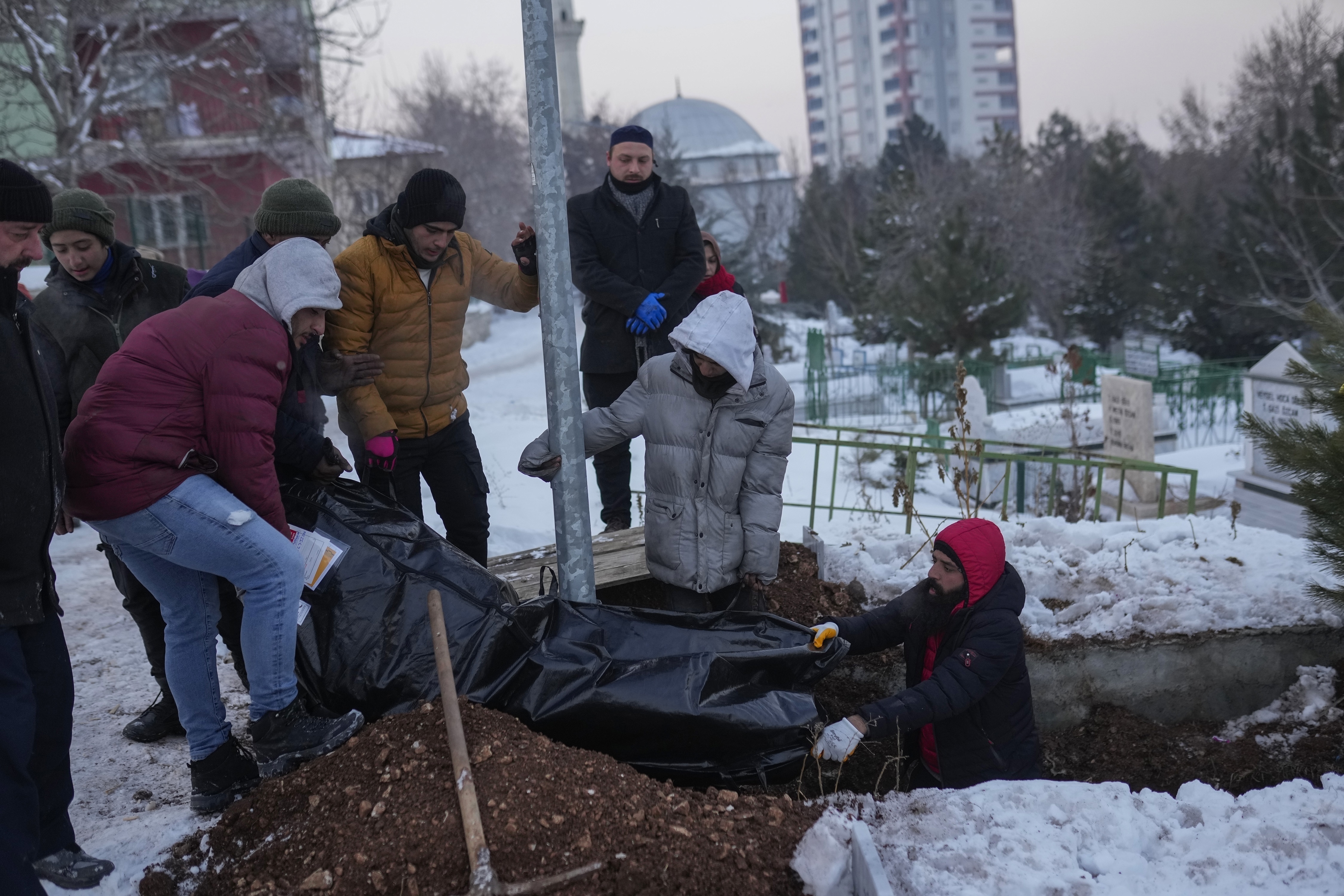 Relatives and friends of Syrian refugee Naziha Al-Ahmad bury her in a cemetery after she died from the earthquake, in Elbistan, Turkey, Friday, Feb. 10, 2023. (AP Photo/Francisco Seco)