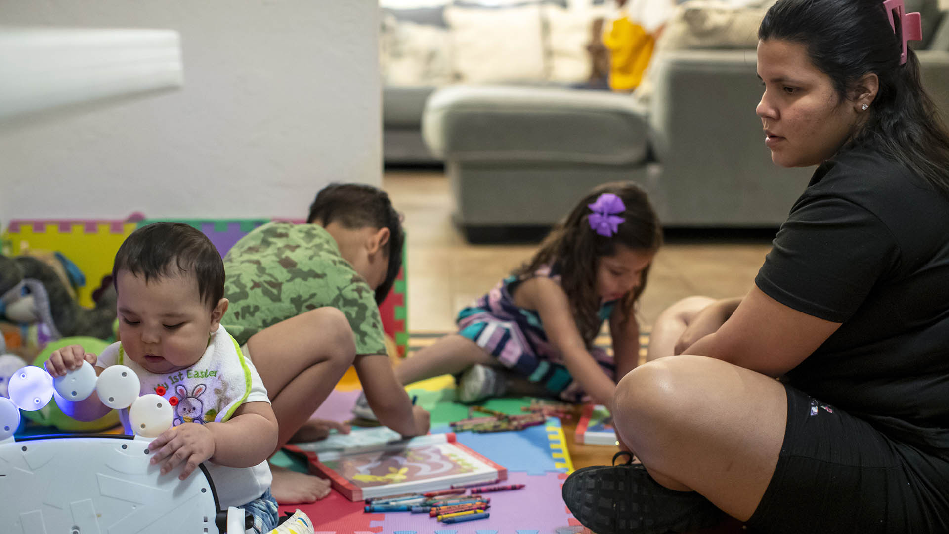 La solicitante de asilo venezolana Oriana Marcano juega con sus hijos, de izquierda a derecha, Adonai, de 8 meses; Stefano, de 5 años, y Amaloha, de 3, en El Paso, Texas, el viernes 12 de mayo de 2023.  (AP Photo/Andres Leighton)

