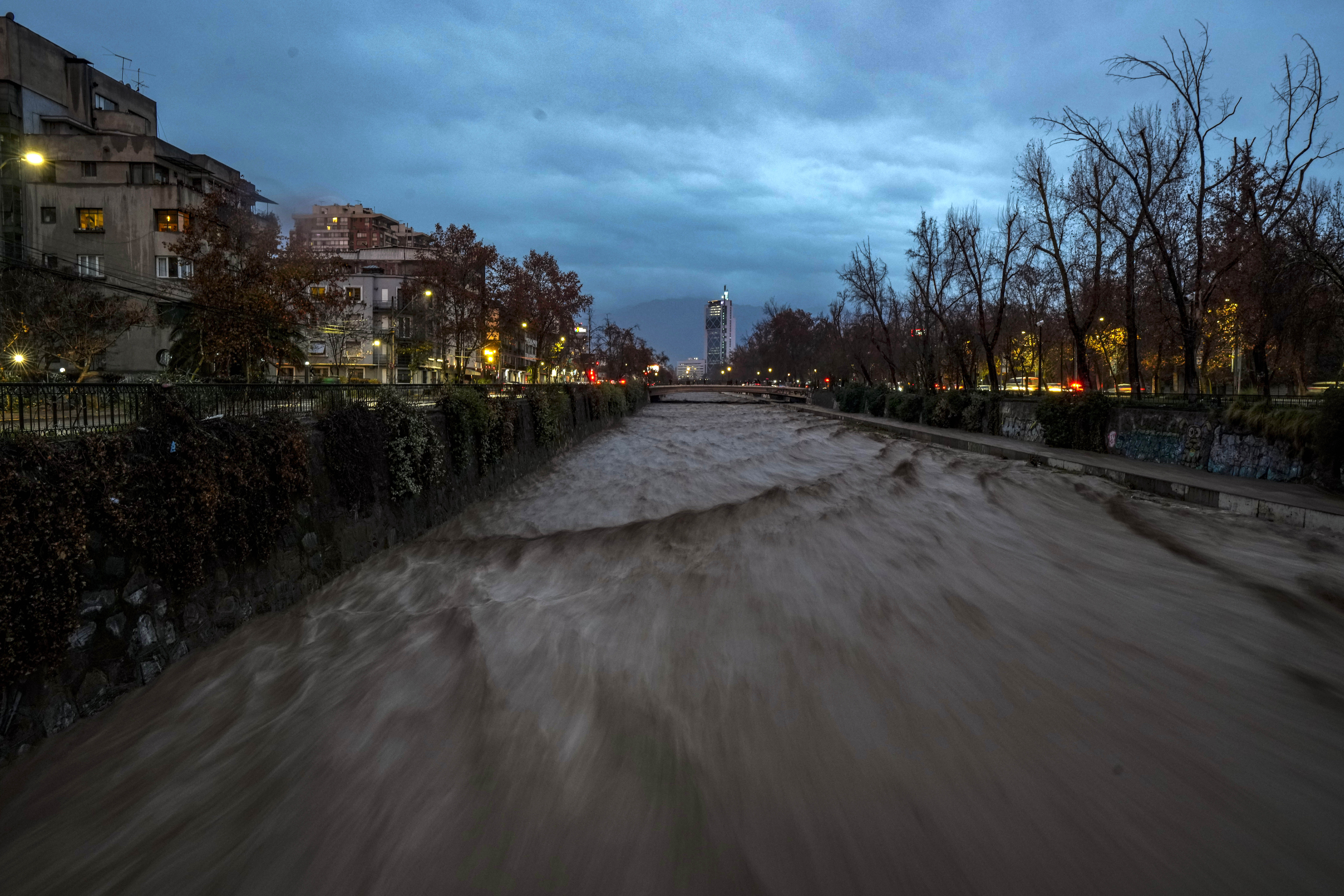 El caudal creciente del río Mapocho durante una fuerte lluvia en el centro de Santiago, Chile, el viernes 23 de junio de 2023. (AP Foto/Esteban Félix)