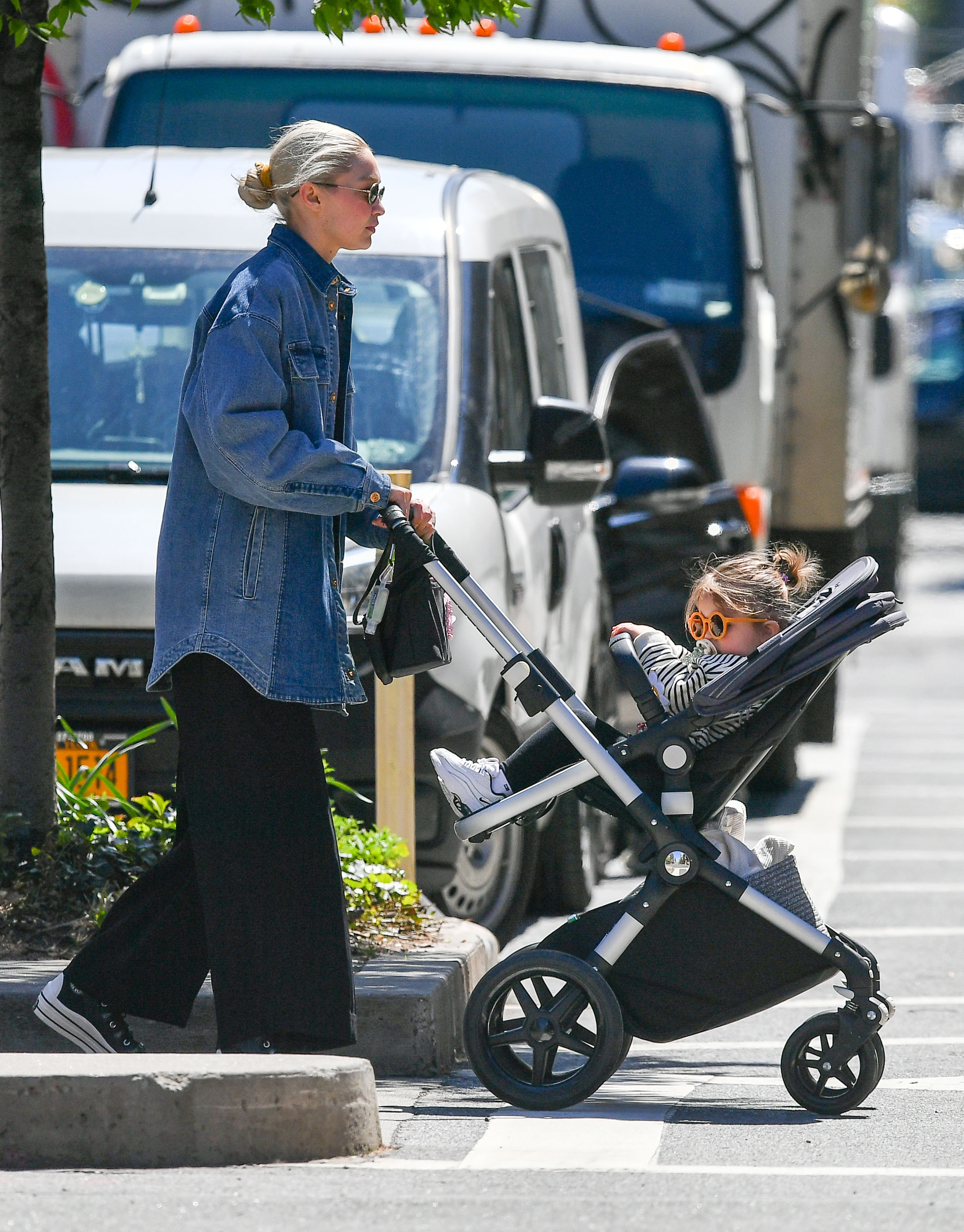 Gigi Hadid fue fotografiada mientras llevaba a pasear a su hija Khai por las calles de Nueva York. Lució unos pantalones anchos negros, zapatillas de lona y campera de jean