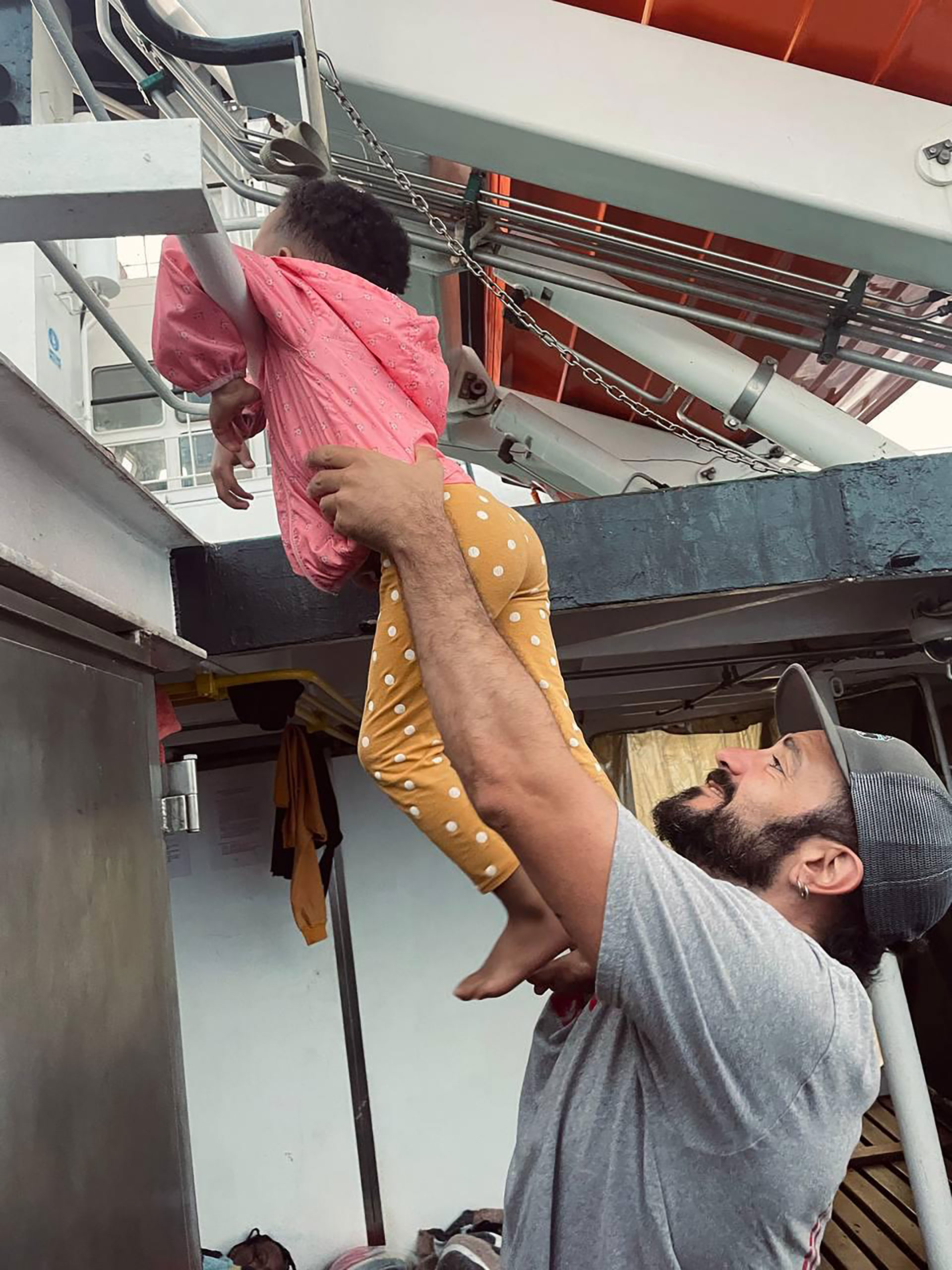 Mauro con una niña migrante en el barco de Open Arms