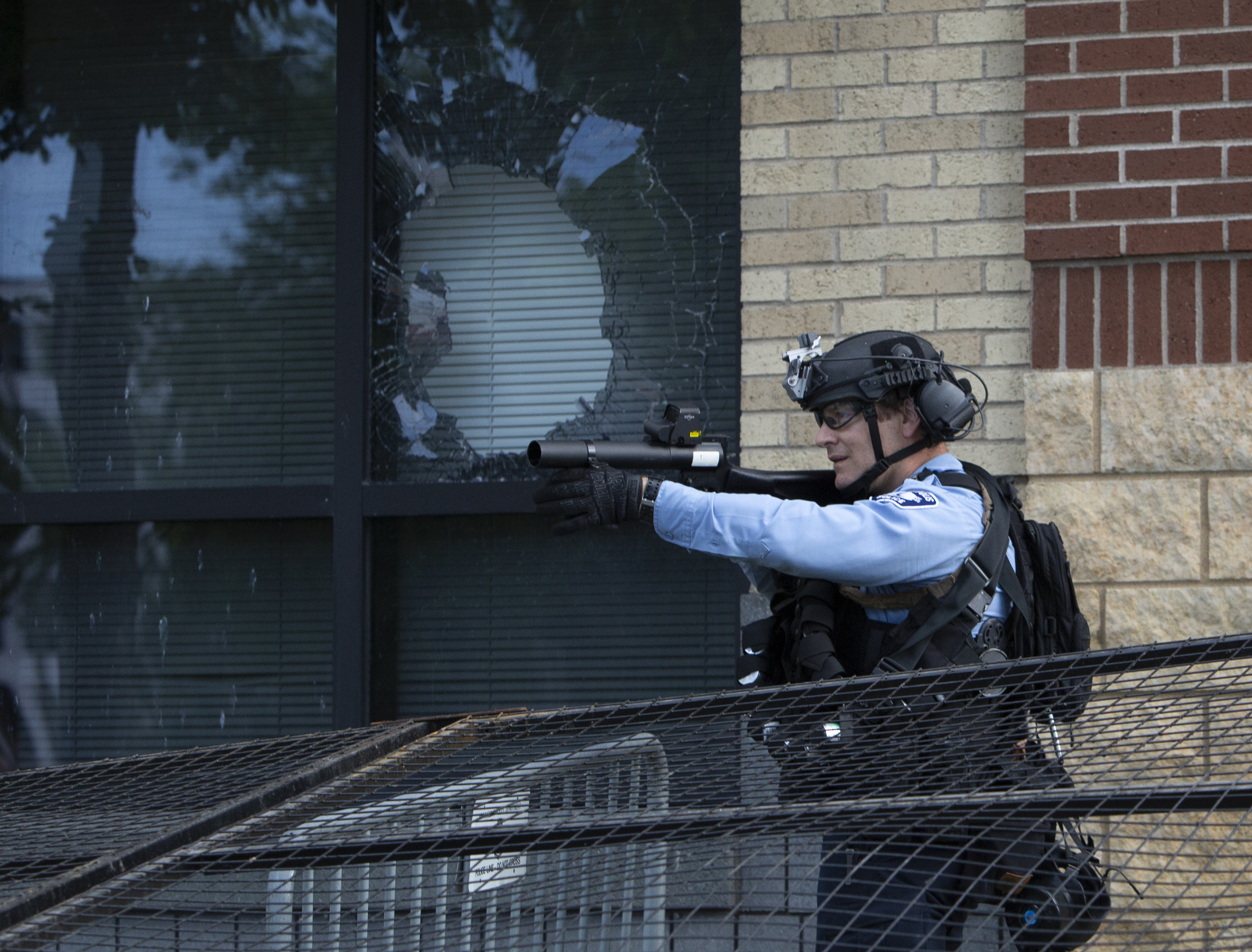 Un agente dispara un proyectil desde la comisaría. (Christine T. Nguyen/Minnesota Public Radio via AP)