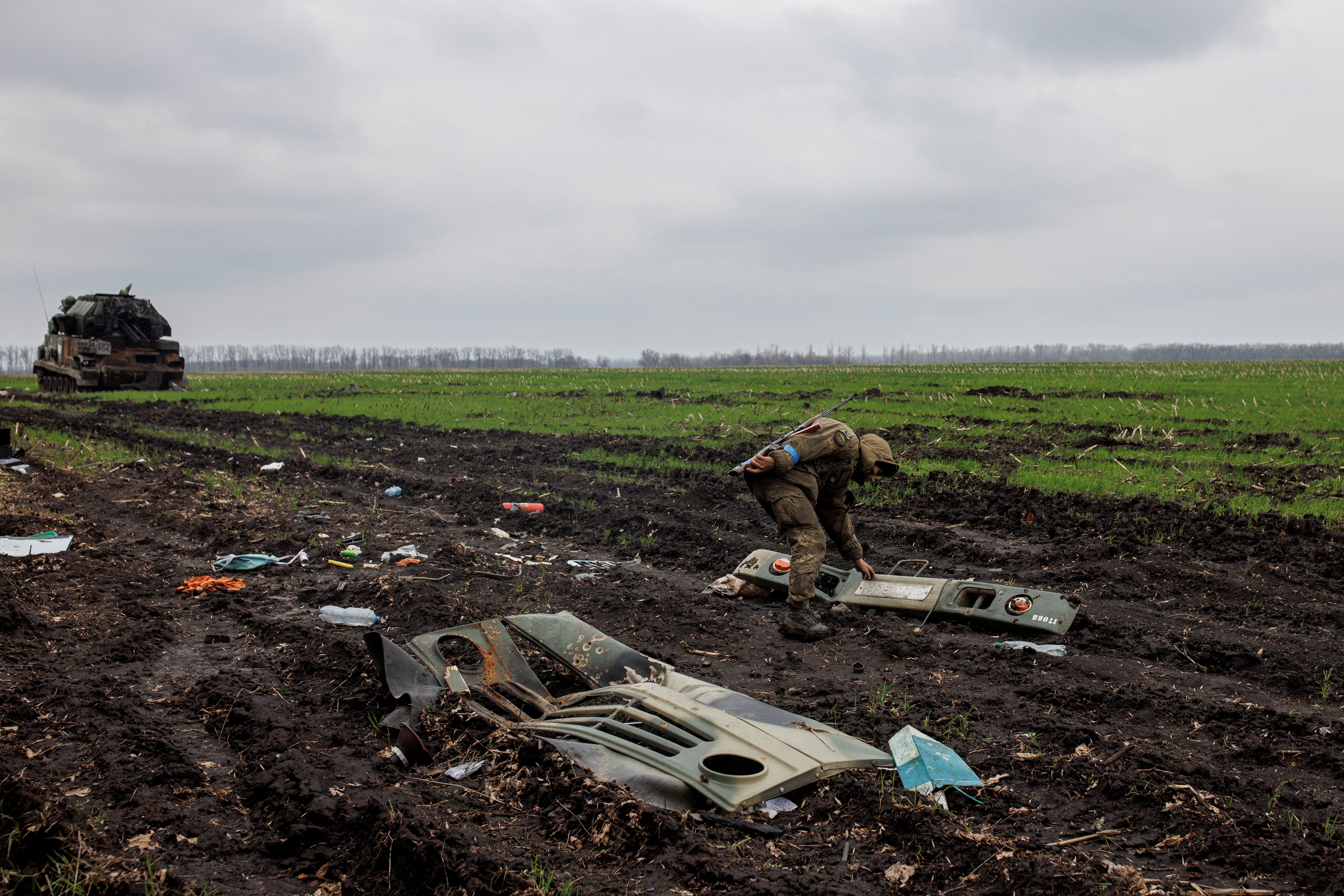 Un soldado ucraniano observa una parte de un vehículo militar ruso destruido, en medio del ataque de Rusia a Ucrania, en el pueblo de Husarivka, en la región de Kharkiv, Ucrania, el 14 de abril de 2022. Imagen tomada el 14 de abril de 2022. REUTERS/Alkis Konstantinidis