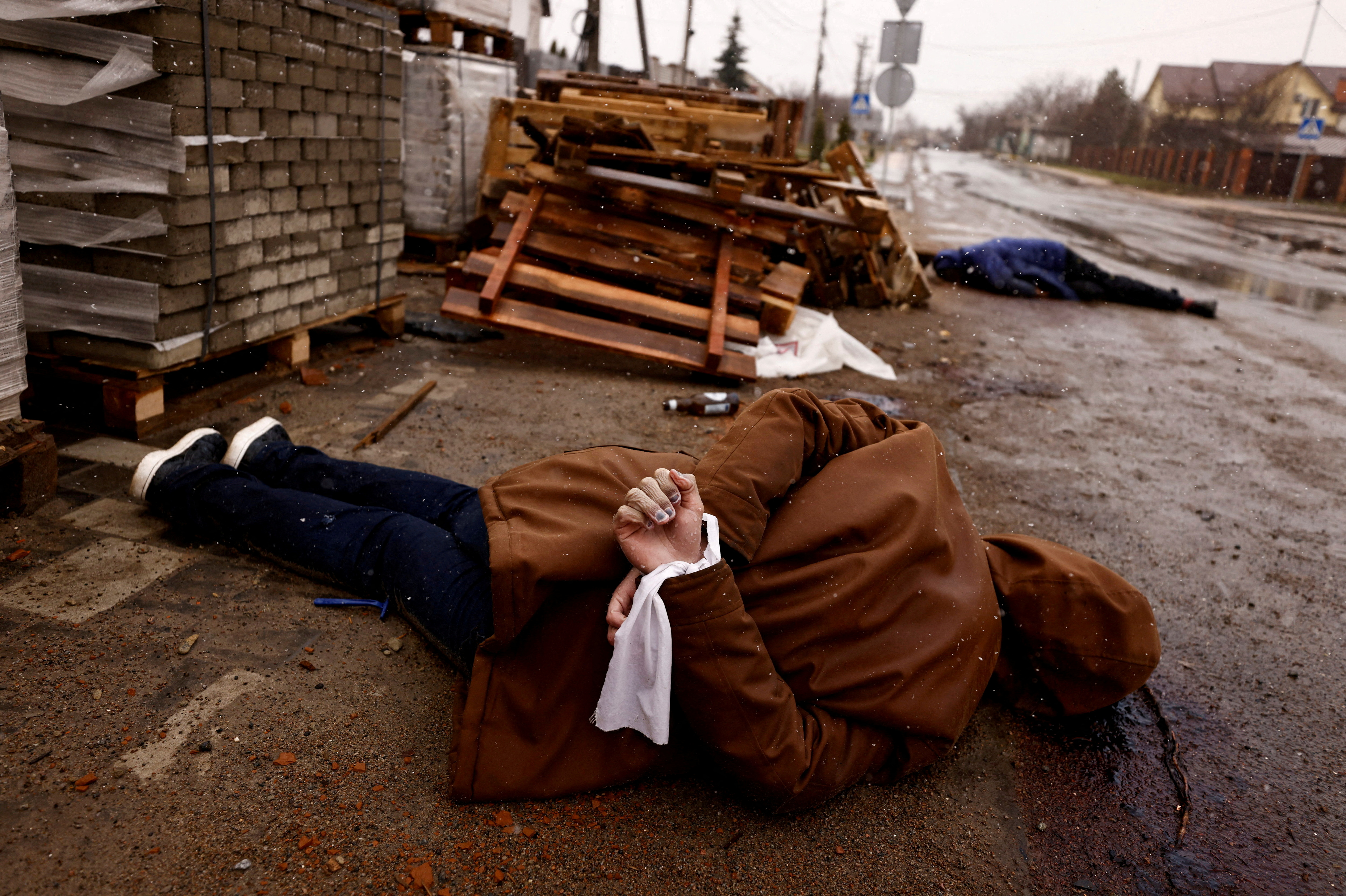 Un cuerpo con las manos atadas con tela blanca, que según los residentes recibió disparos de soldados rusos, yace en la calle, en medio de la invasión de Rusia a Ucrania, en Bucha (Reuters)
