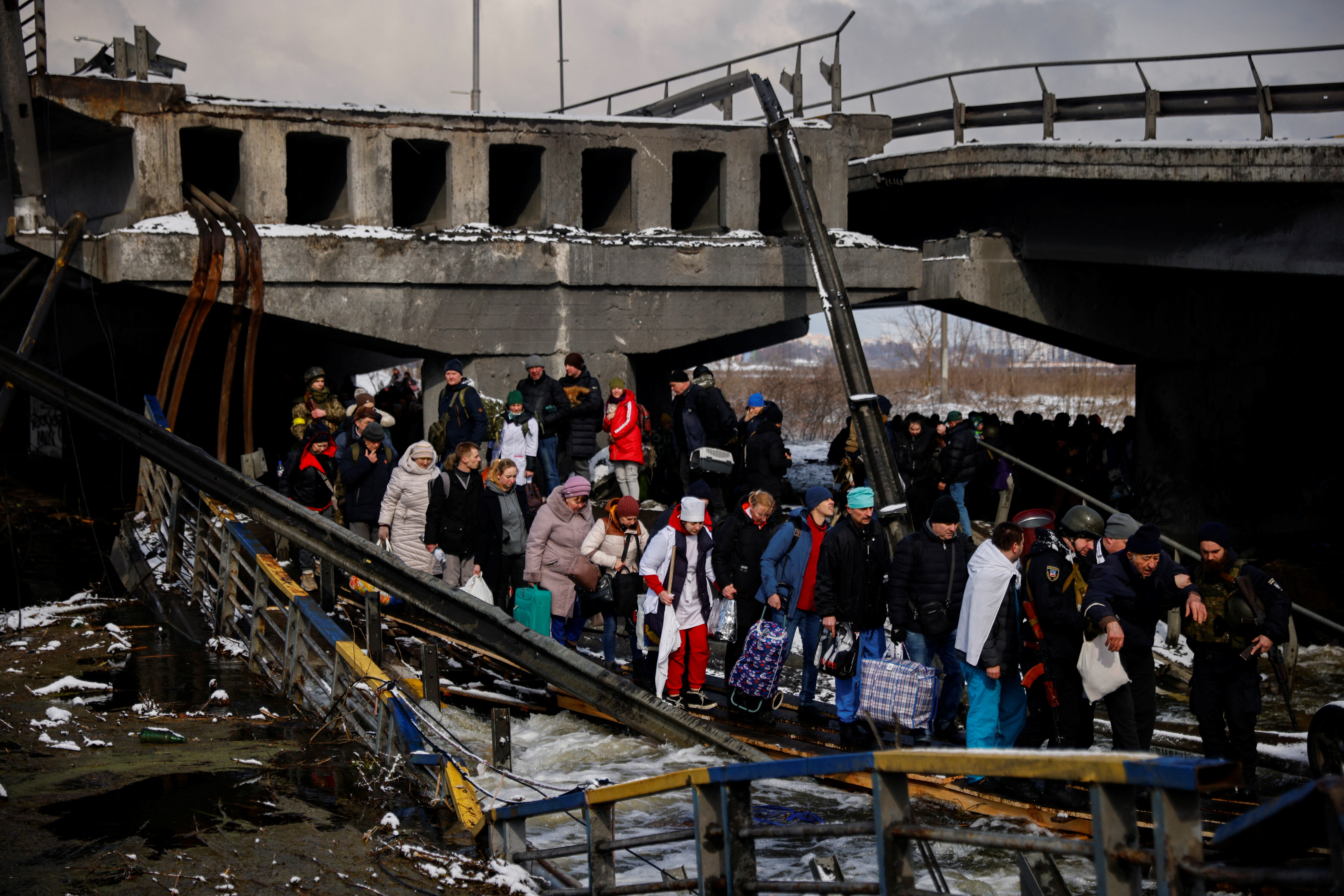 La gente de Irpin es evacuada a través de un puente destruido (REUTERS/Thomas Peter)